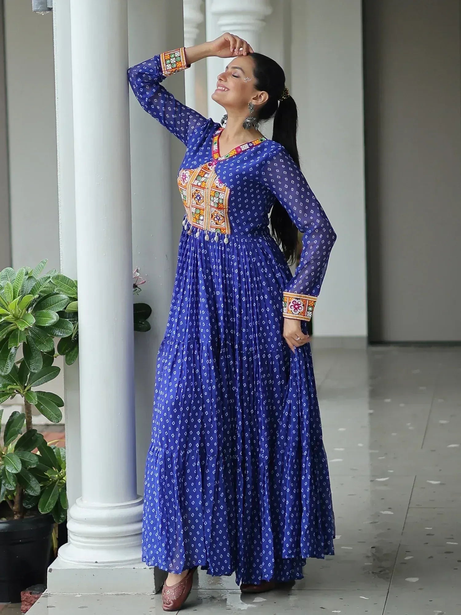 Woman in blue ethnic gown with mirror work and printed patterns, perfect for Indian occasions