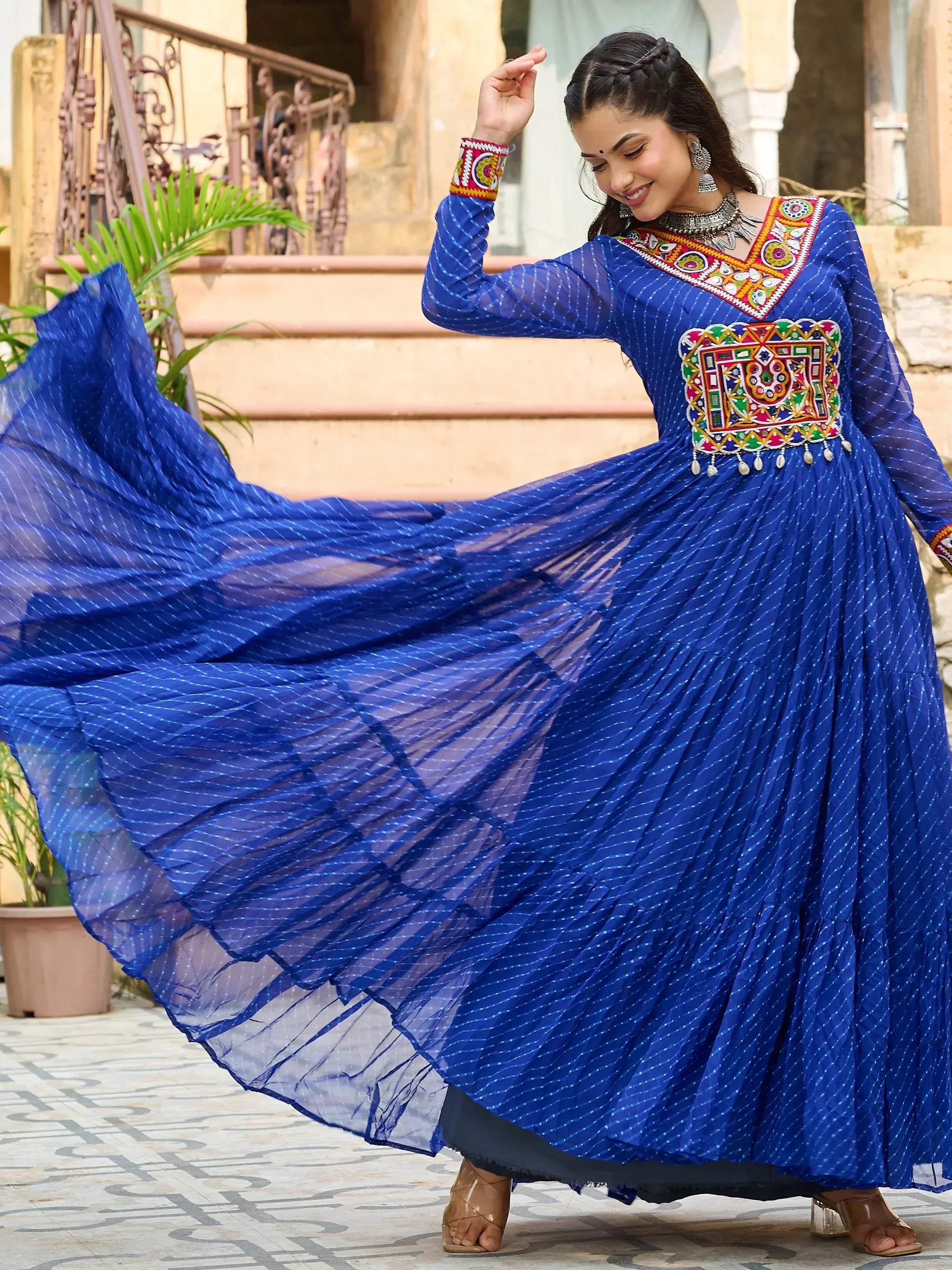 Woman twirling in blue ethnic gown with mirror work, perfect for Indian festive occasions