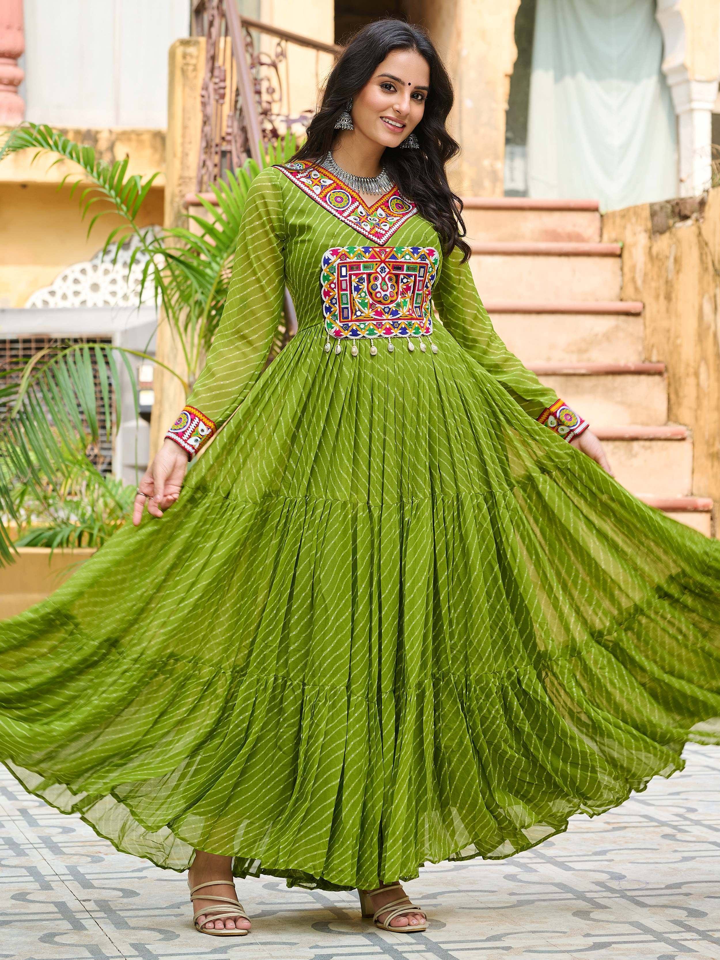 Green ethnic gown with colorful mirror work and pleated skirt, perfect for Indian festivals and occasions.