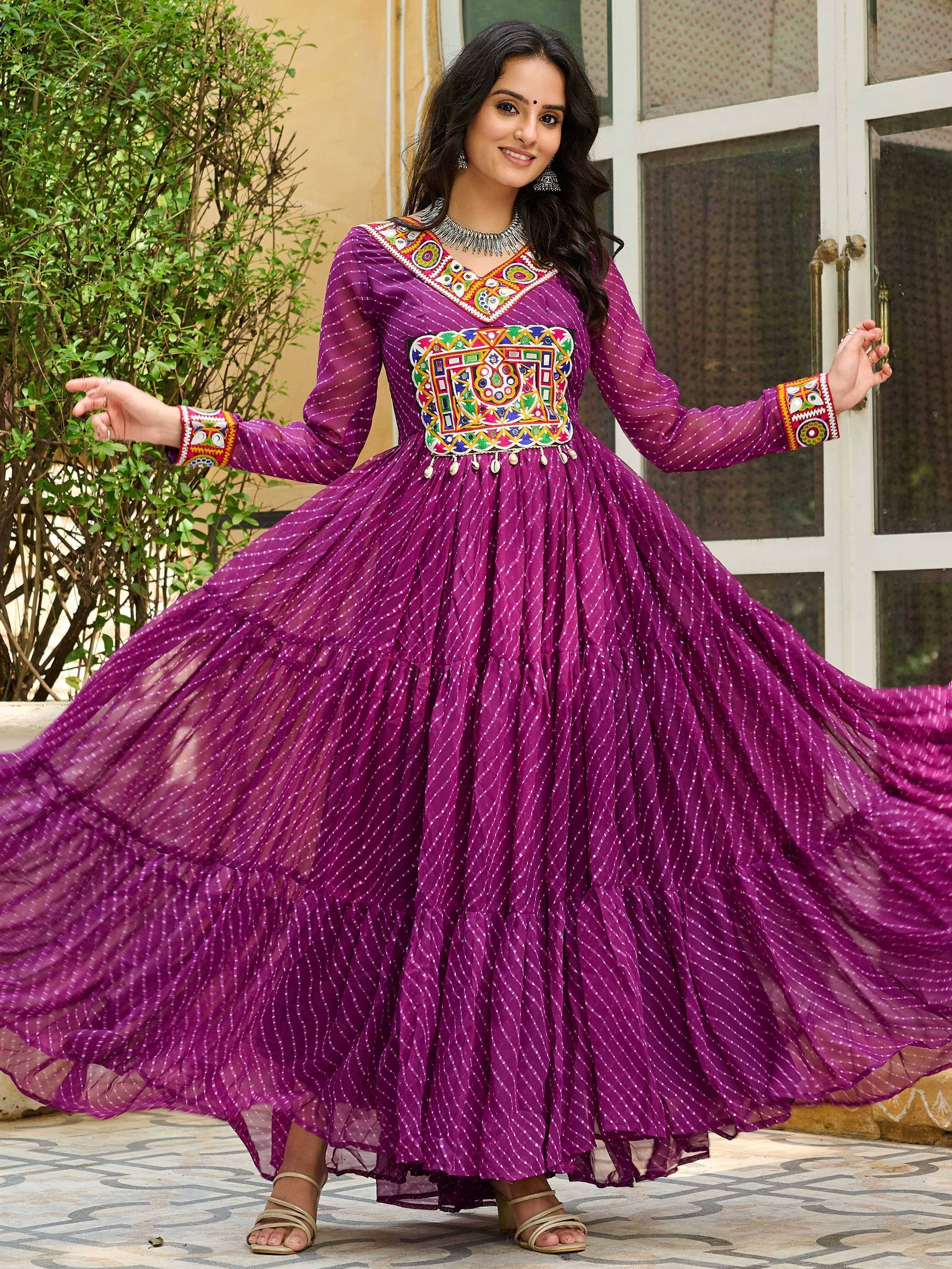 Purple ethnic gown with colorful mirror work and flared skirt, perfect for festive occasions.