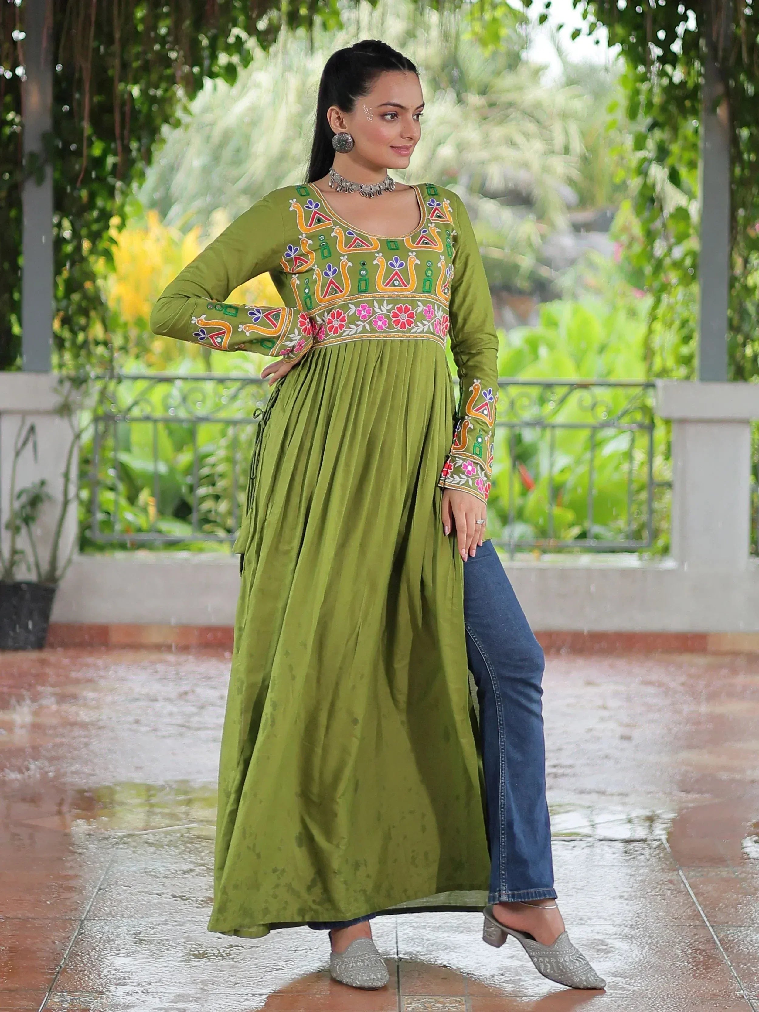 Olive green embroidered ethnic kurta with floral and peacock motifs, paired with jeans for a fusion look.