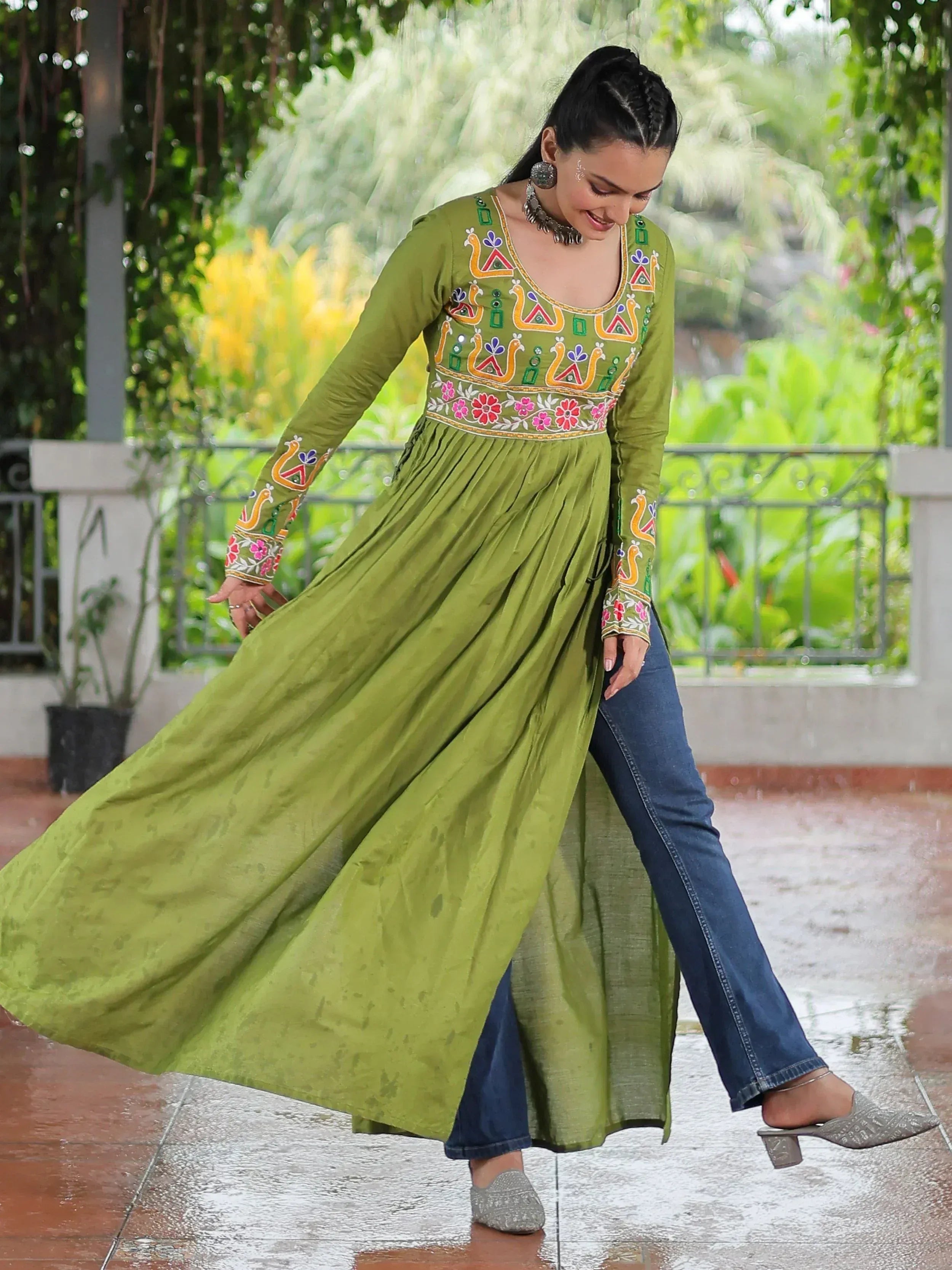 Olive green embroidered ethnic kurti with floral and peacock motifs, paired with jeans for a fusion look