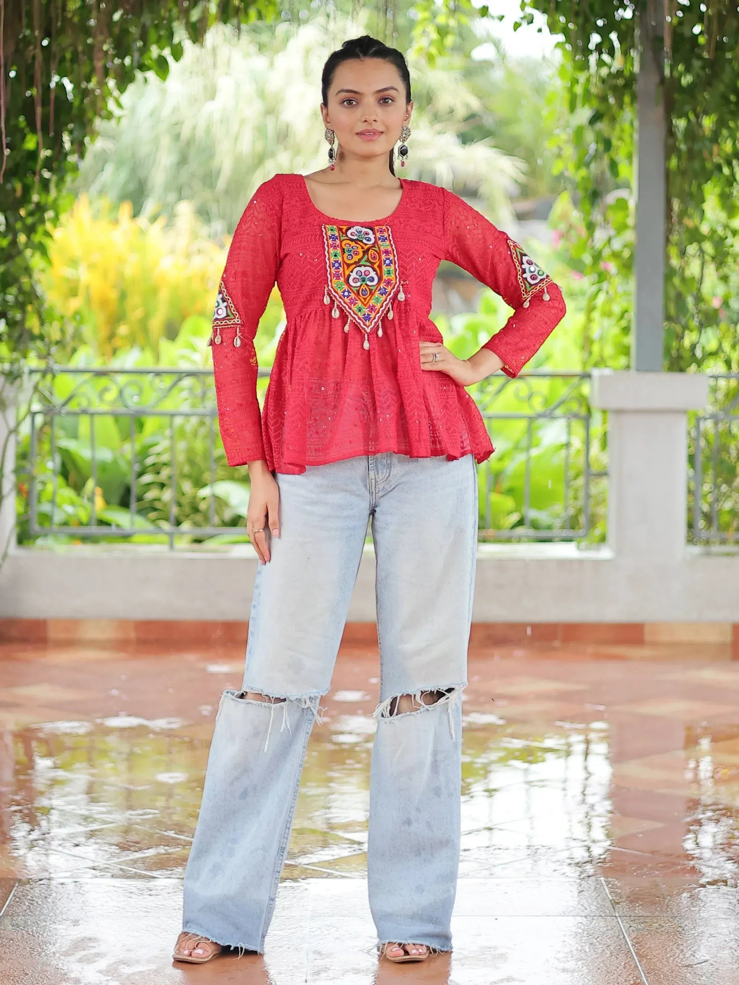 Red embroidered ethnic top with bell sleeves paired with ripped denim jeans, perfect for casual Indian wear