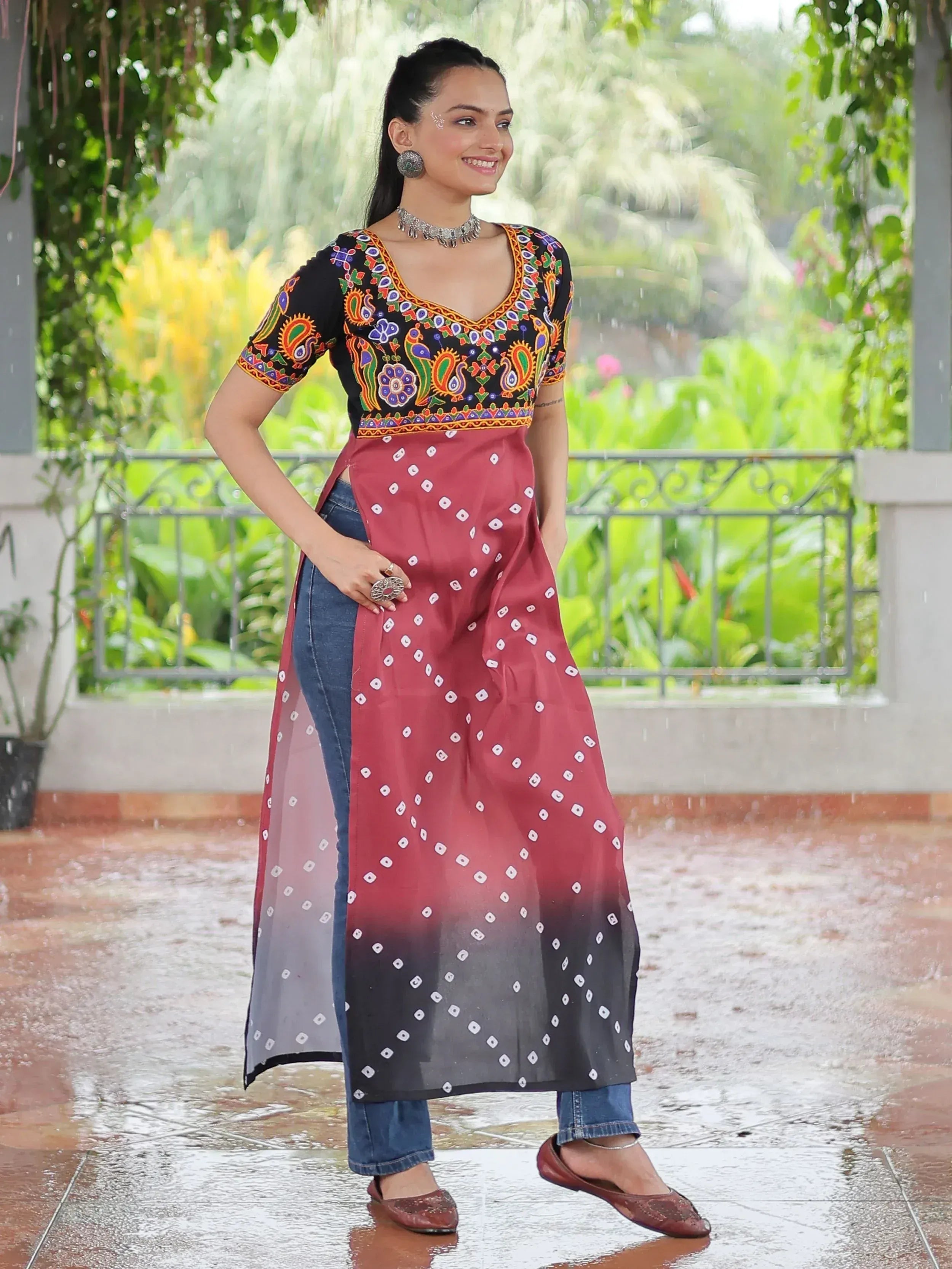 Woman in embroidered black top with red ombre dupatta, styled with jeans for ethnic fusion look