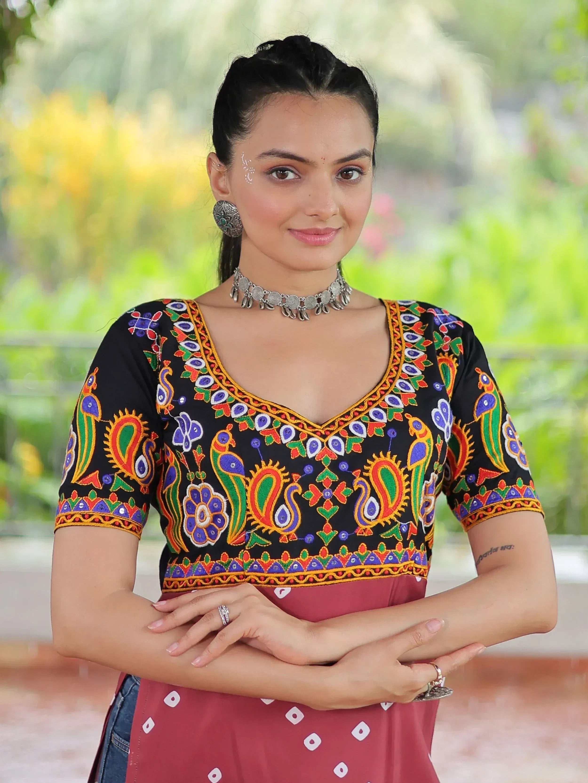Black embroidered ethnic top with peacock motifs, paired with red bandhani skirt, perfect for Indian wear.