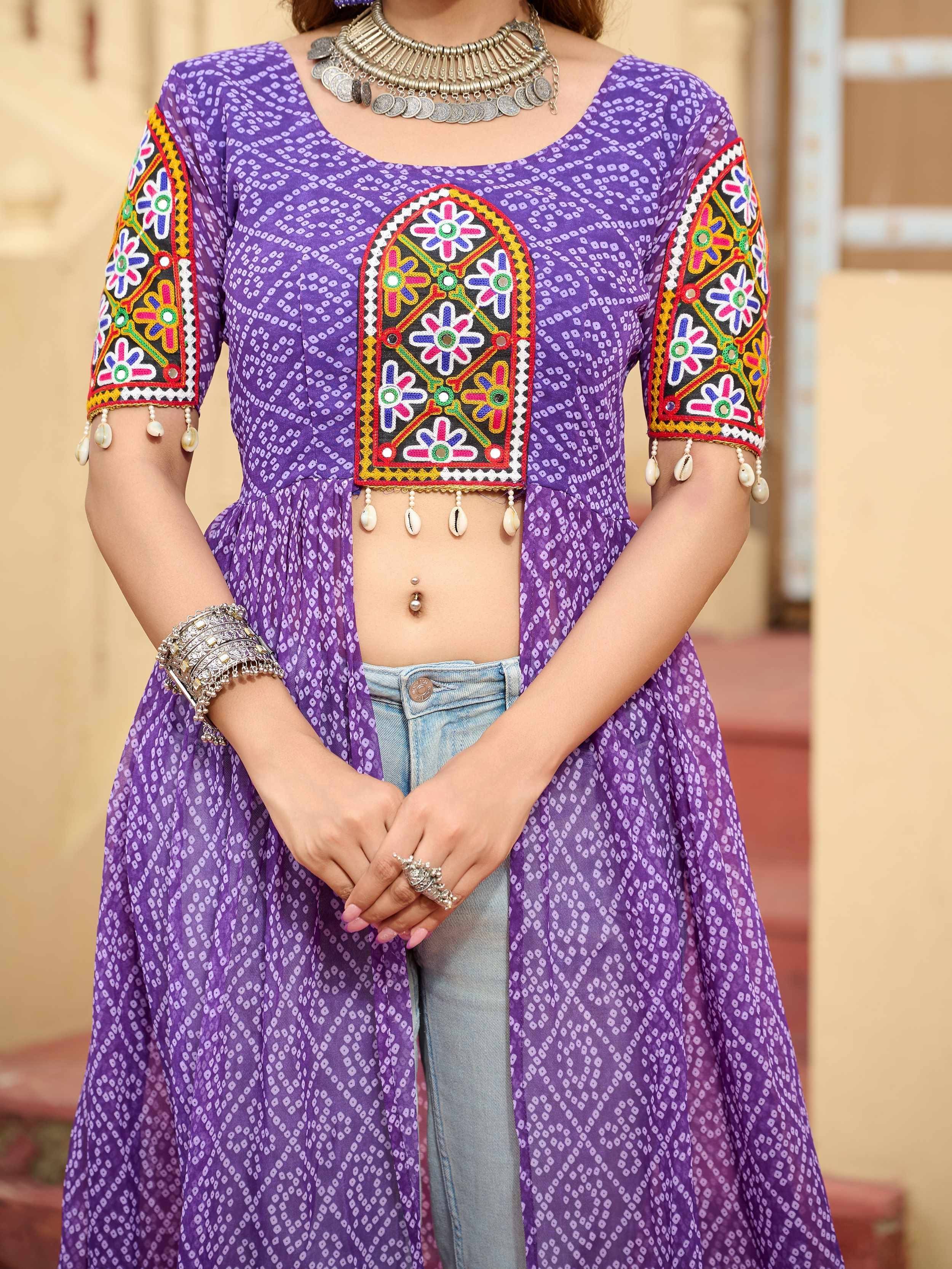 Purple ethnic kurti with colorful floral embroidery, mirror work, and shell tassels, paired with jeans