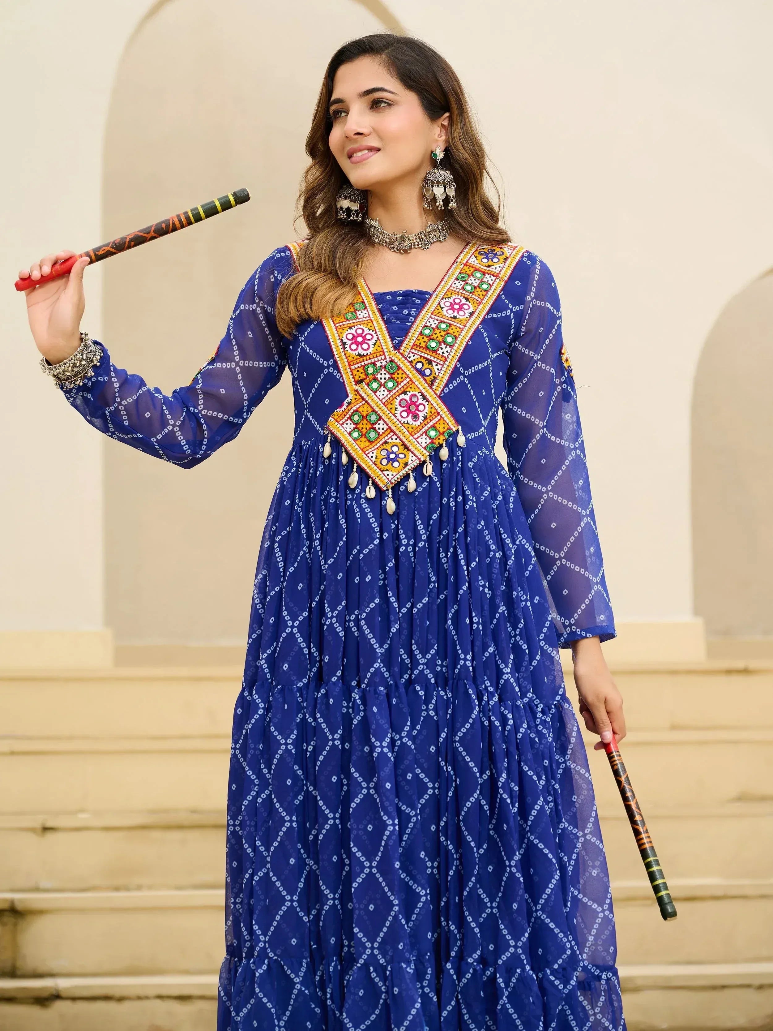 Blue ethnic gown with floral embroidery and mirror work, paired with traditional jewelry