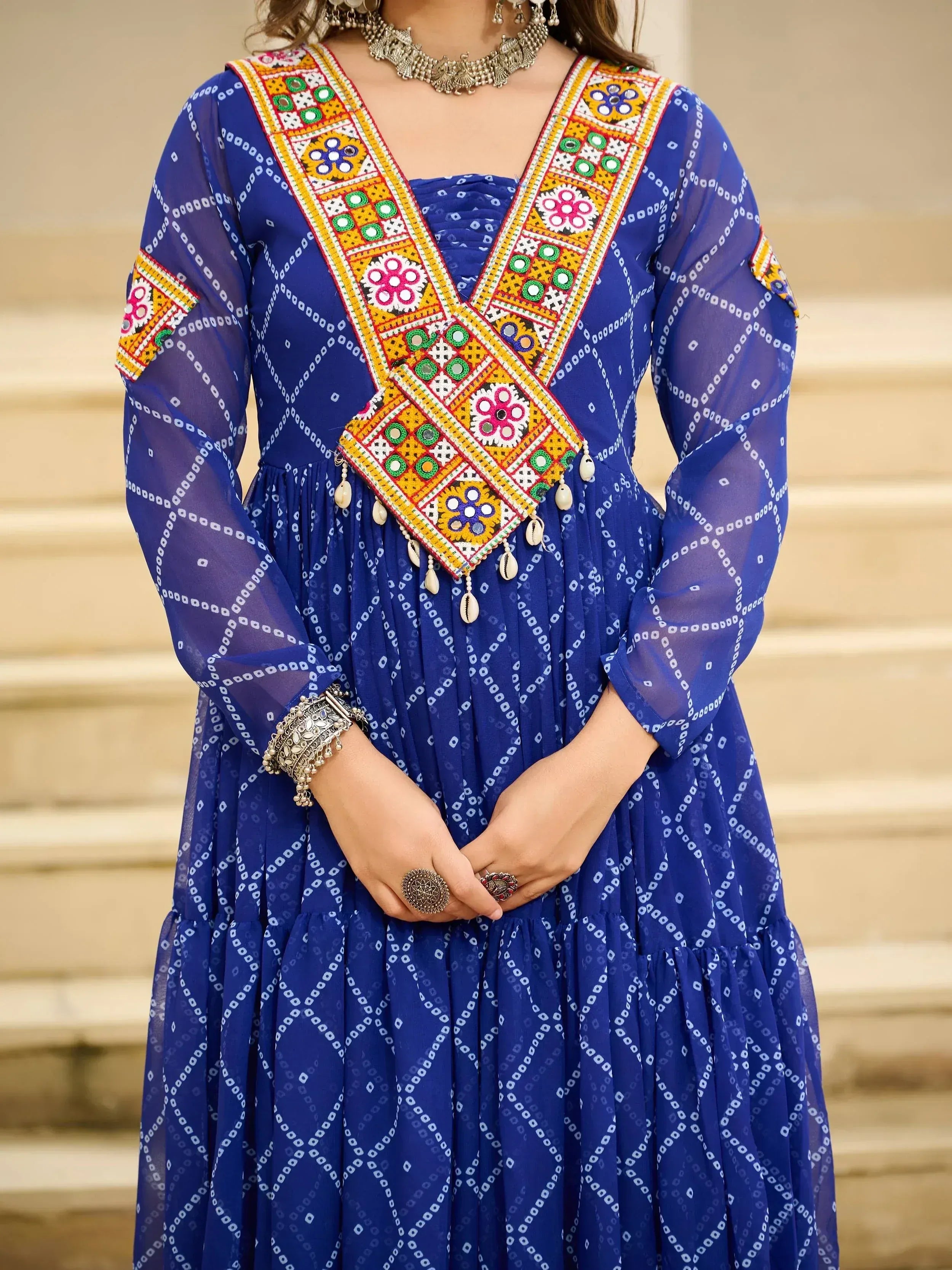 Blue ethnic gown with vibrant mirror work and traditional jewelry, perfect for Indian festive occasions