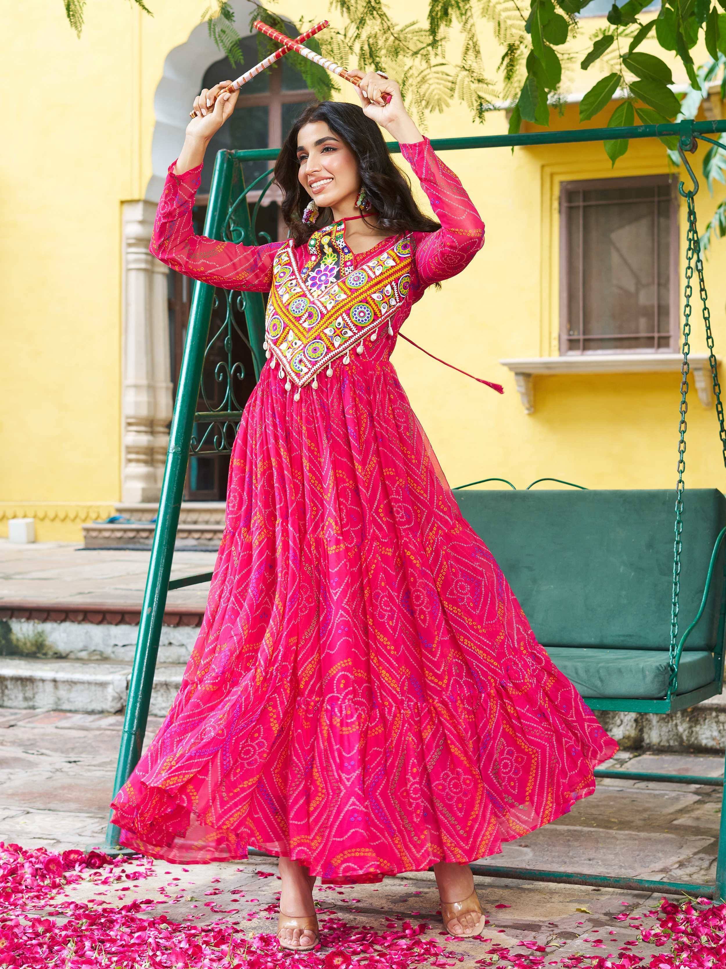 Vibrant pink embroidered ethnic gown with mirror work, perfect for festive occasions and celebrations.