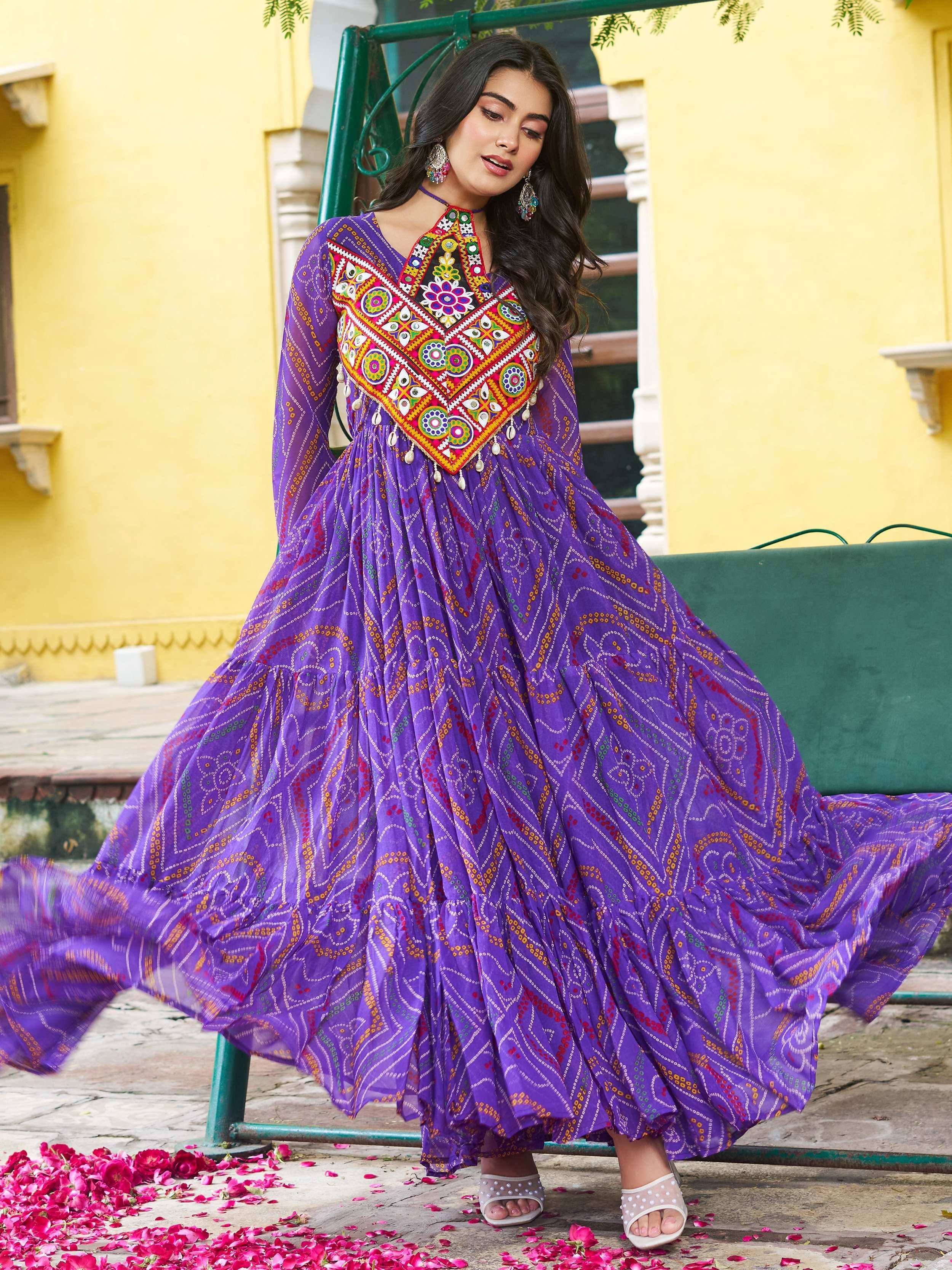 Purple ethnic gown with vibrant mirror work and floral embroidery, perfect for festive occasions.