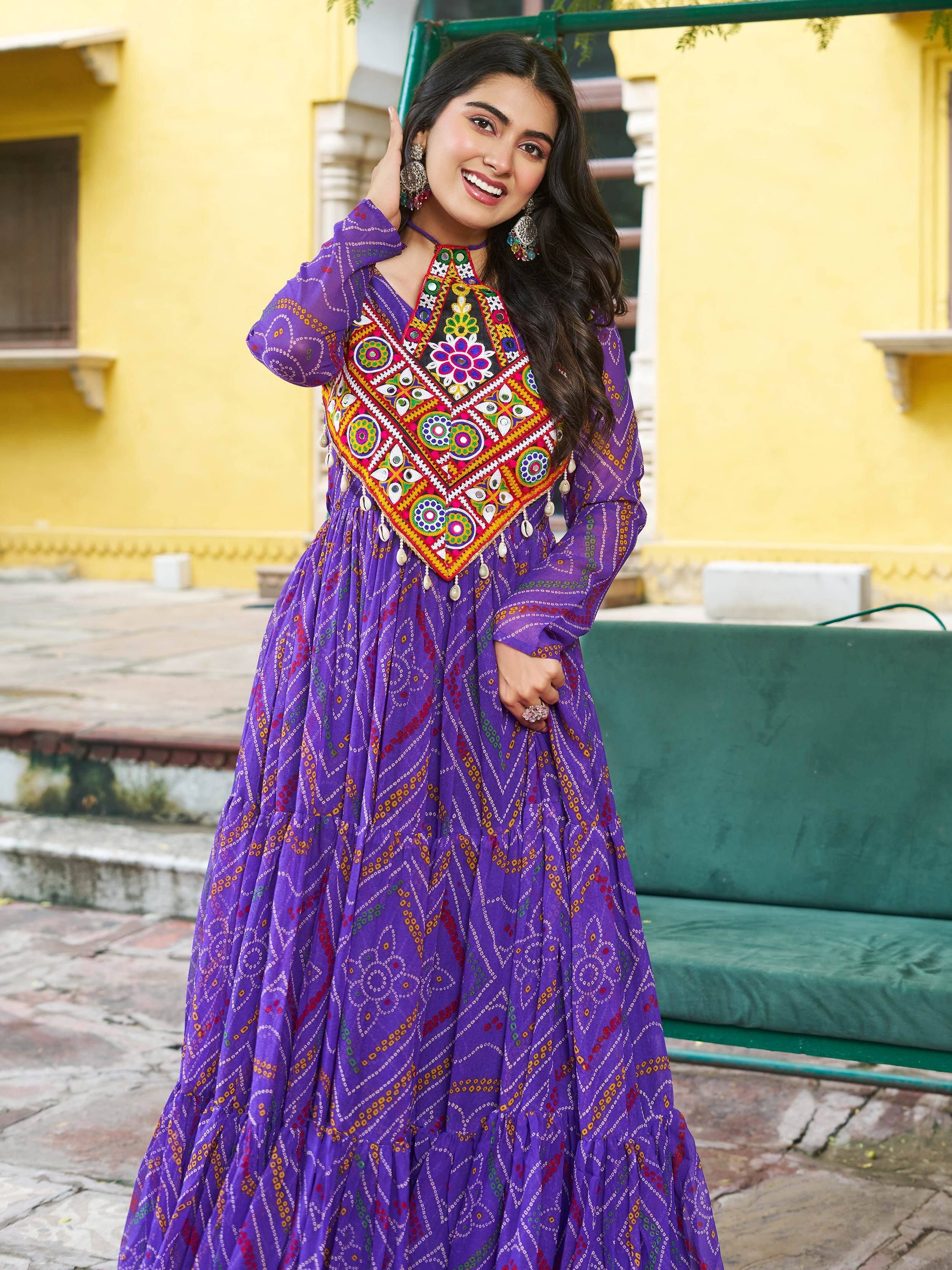 Purple ethnic gown with vibrant mirror work and printed patterns, perfect for Indian festive occasions.