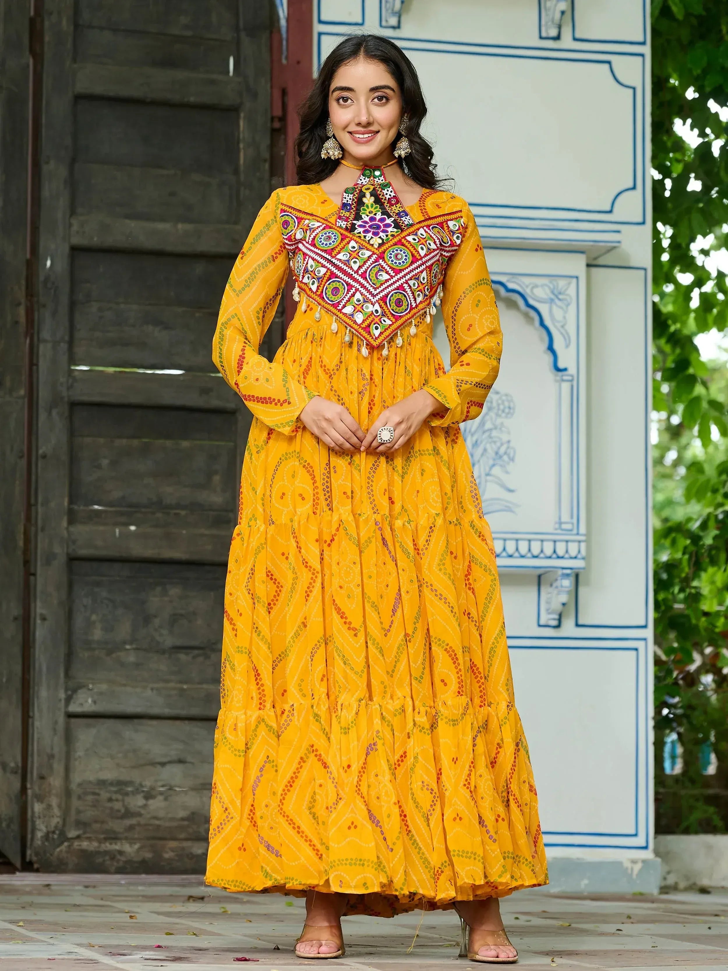 Yellow ethnic gown with colorful mirror work and embroidery, perfect for Indian festive occasions