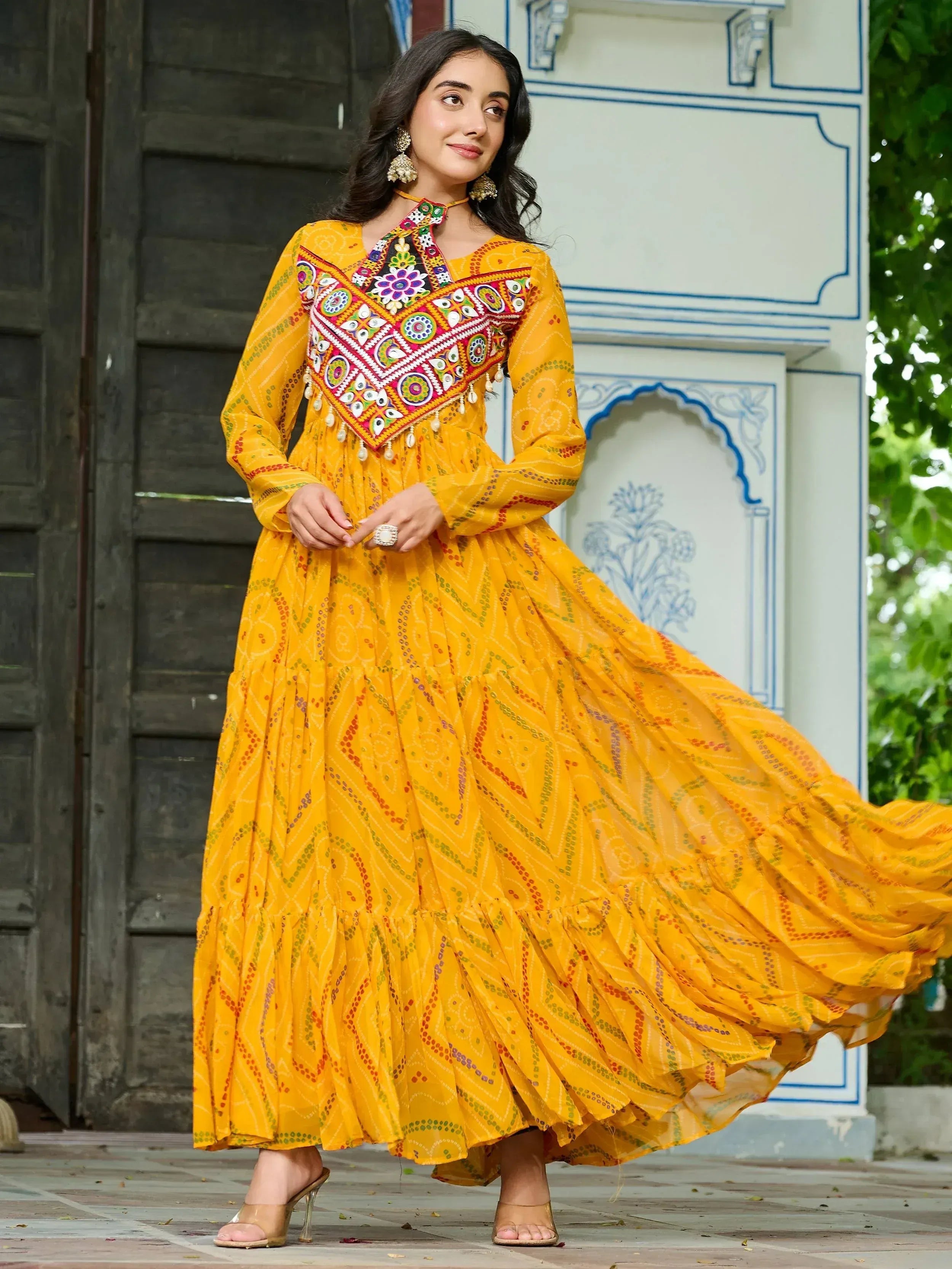 Yellow ethnic gown with mirror work and embroidery, perfect for Indian festivals and occasions.