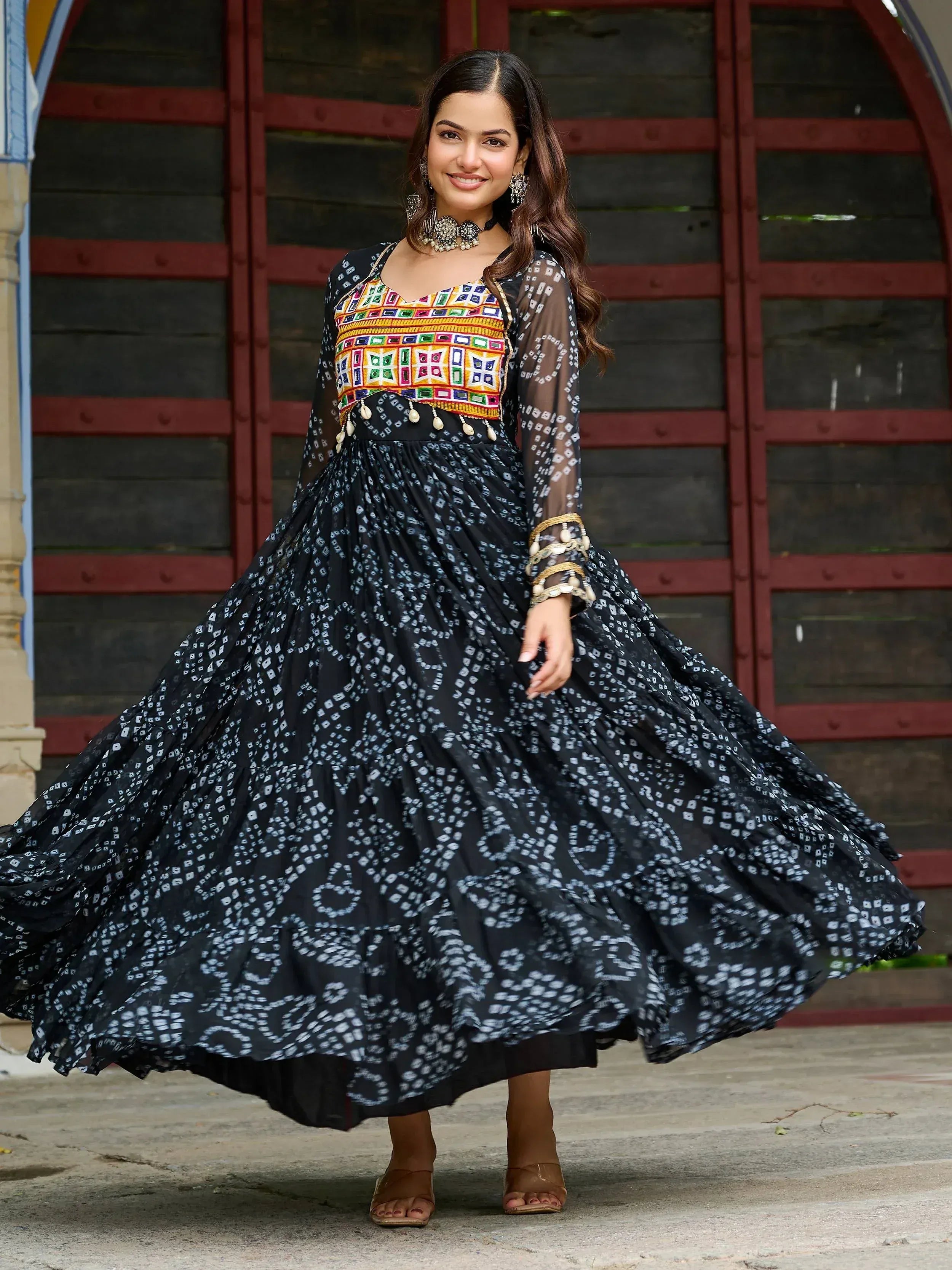 Woman in black printed ethnic gown with colorful embroidered top, perfect for Indian festive occasions