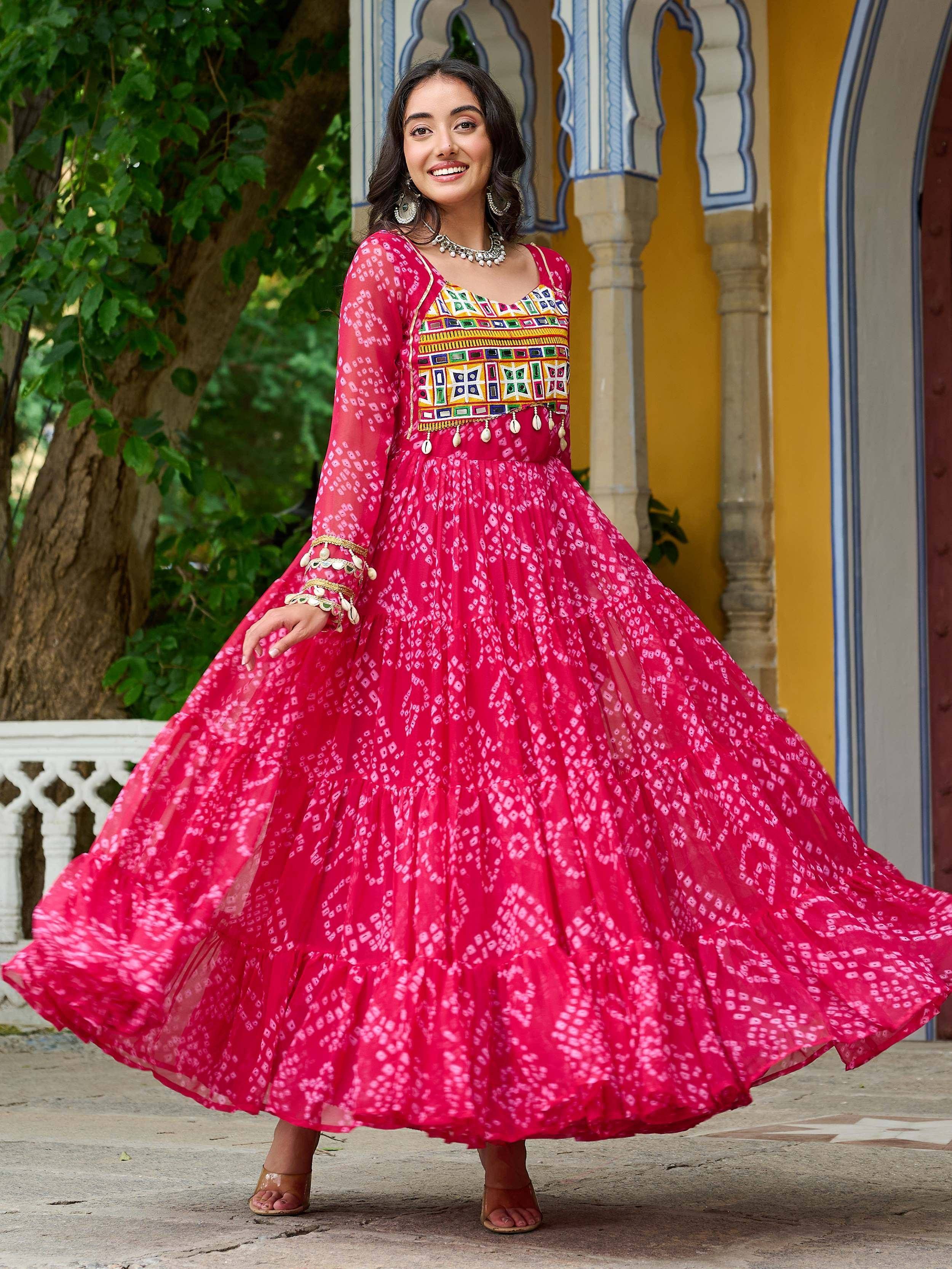 Vibrant pink ethnic gown with mirror work and printed skirt, perfect for Indian festive occasions