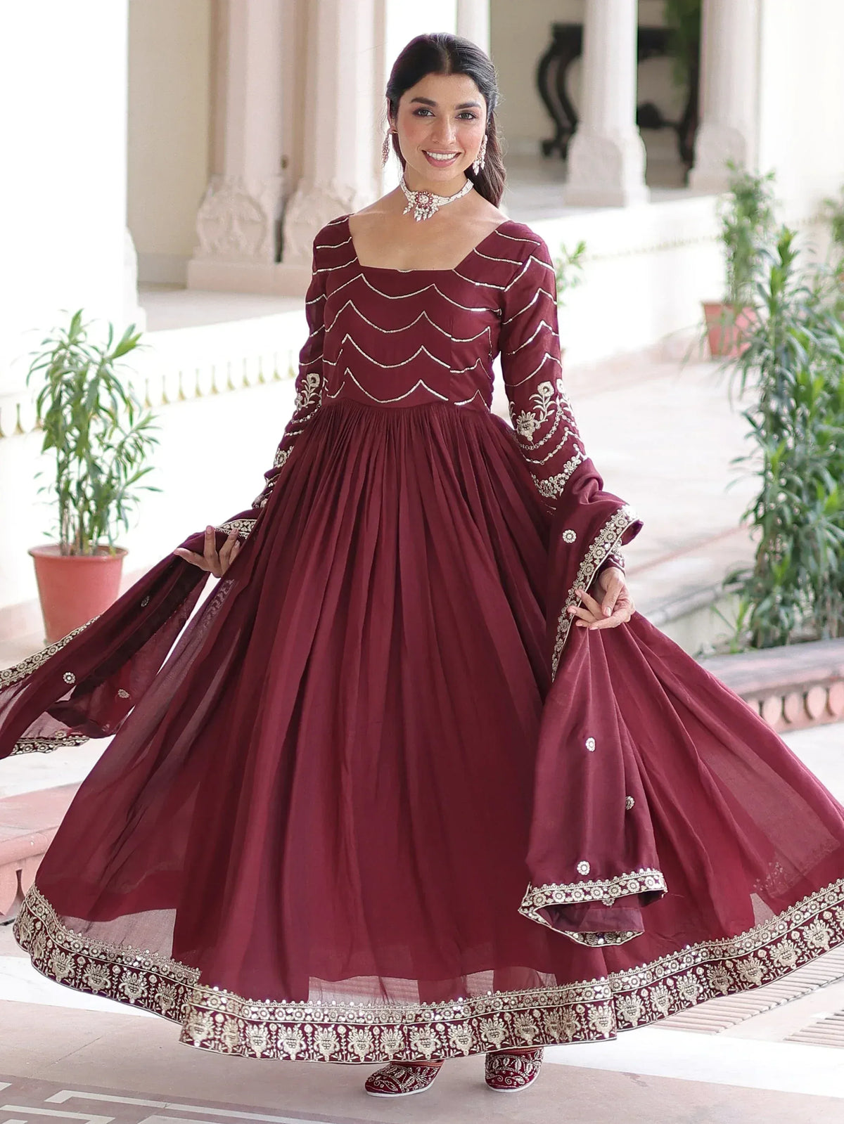Maroon ethnic gown with gold embroidery, perfect for Indian festive occasions and weddings.