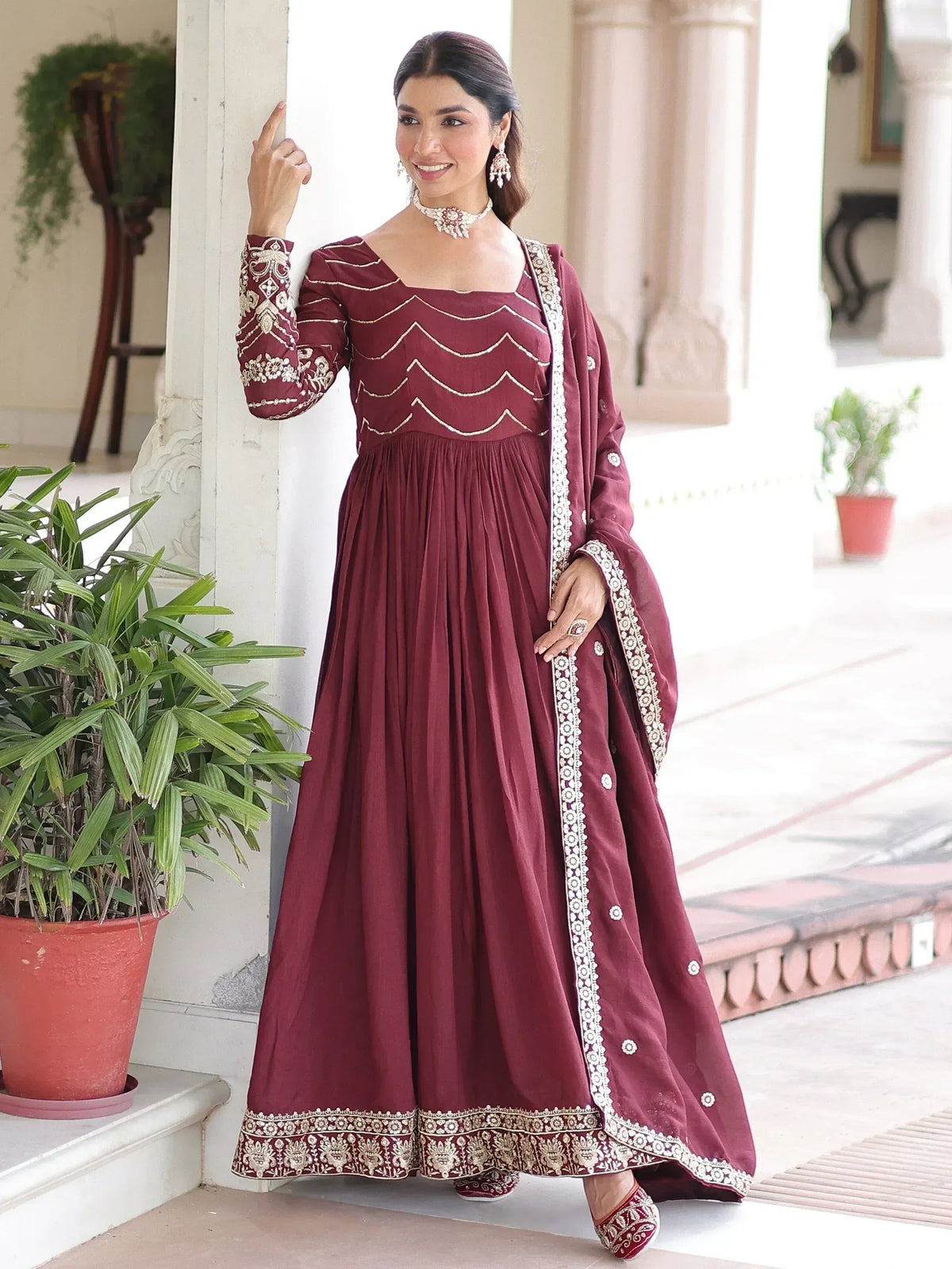 Maroon ethnic gown with gold embroidery, perfect for Indian festive occasions and weddings.