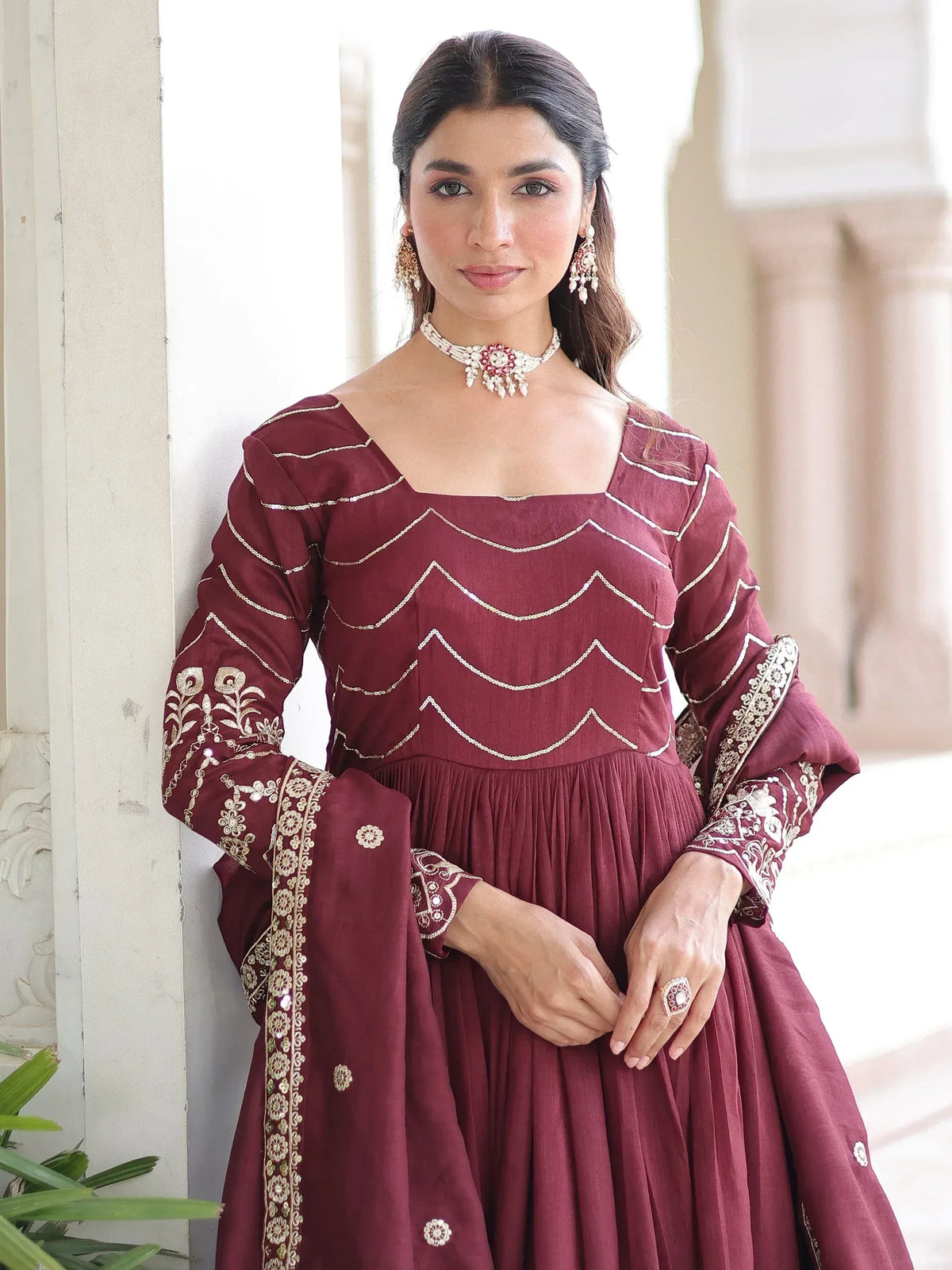 Maroon ethnic gown with gold embroidery, perfect for Indian weddings and festive occasions.
