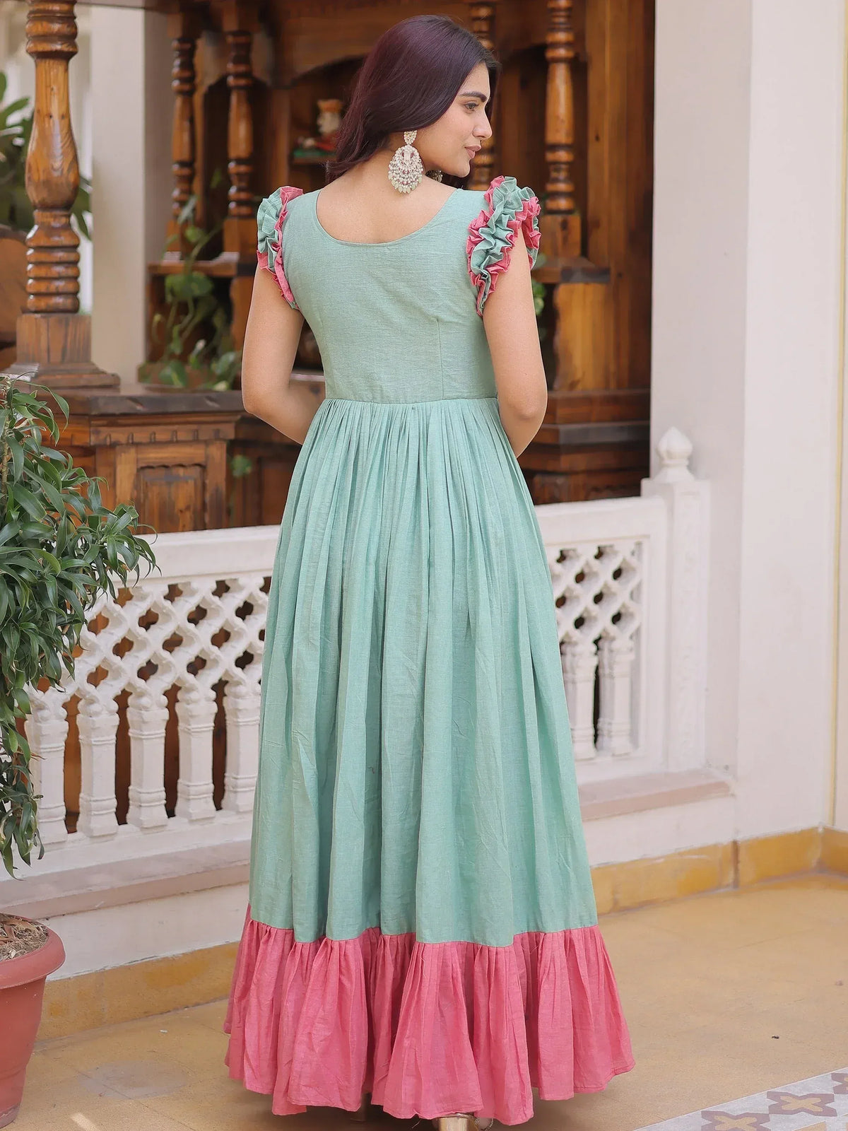 Mint green ethnic gown with pink ruffle sleeves and hem, perfect for Indian occasions