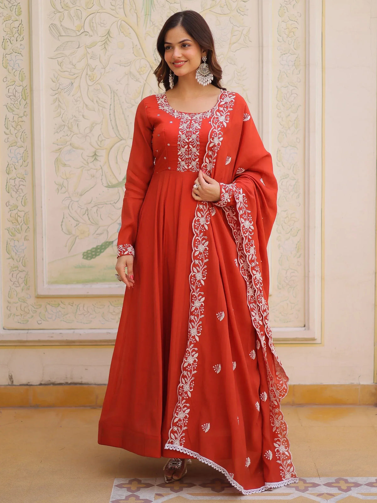 Woman wearing a red embroidered Anarkali suit with matching dupatta