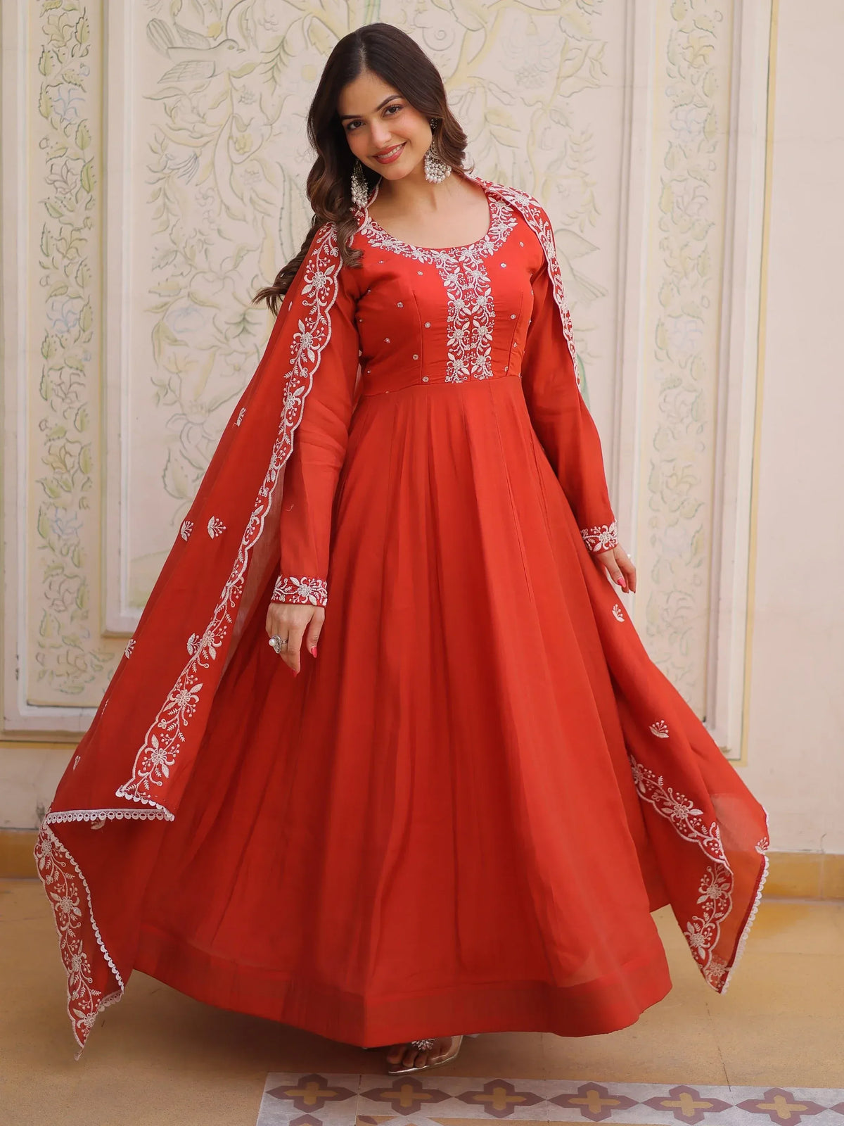 Woman wearing a red ethnic gown with white embroidery and a matching dupatta