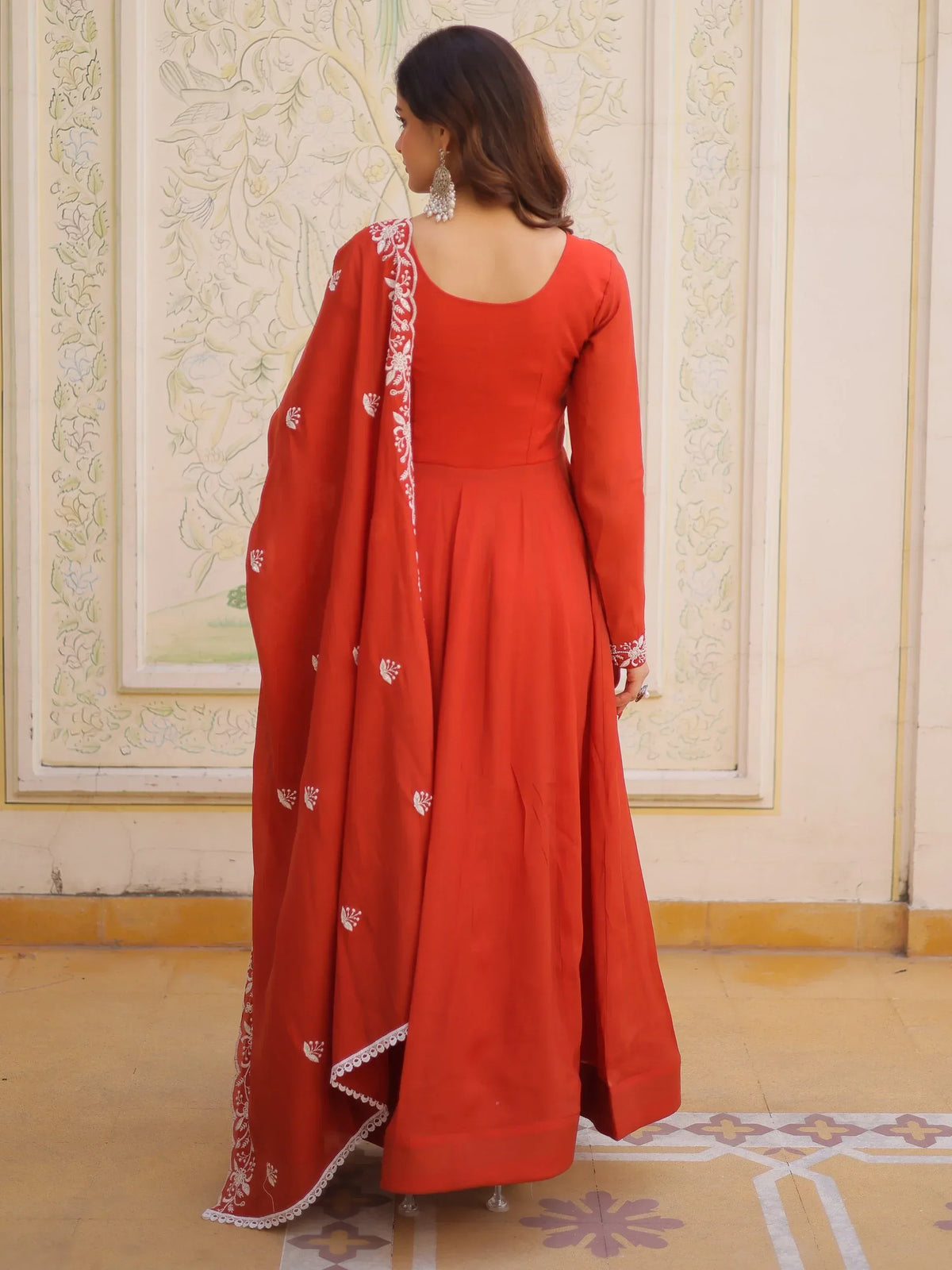 Woman in a red long ethnic gown with white embroidery and matching dupatta