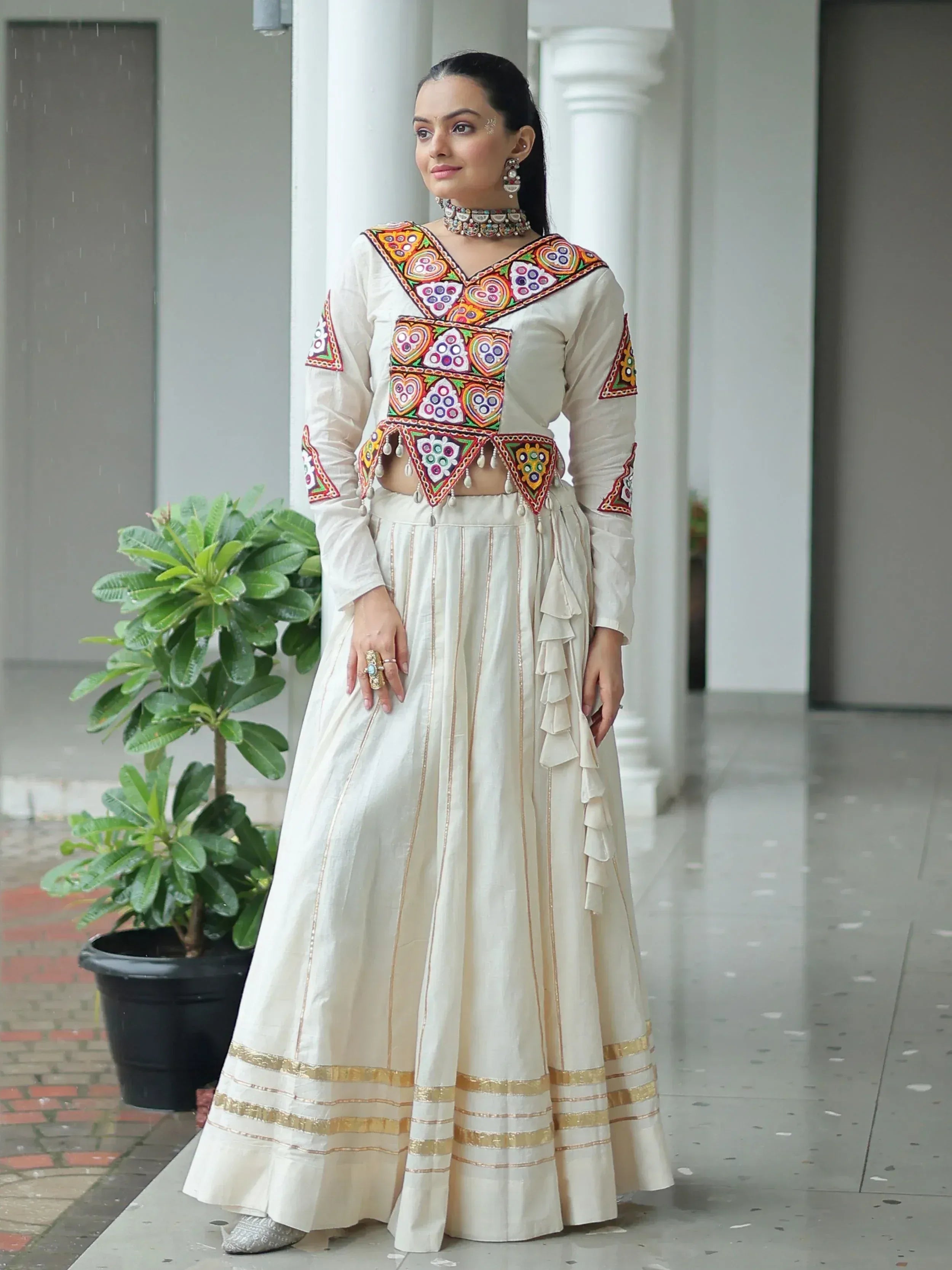 Cream embroidered lehenga choli with colorful mirror work, perfect for Indian ethnic wear occasions.