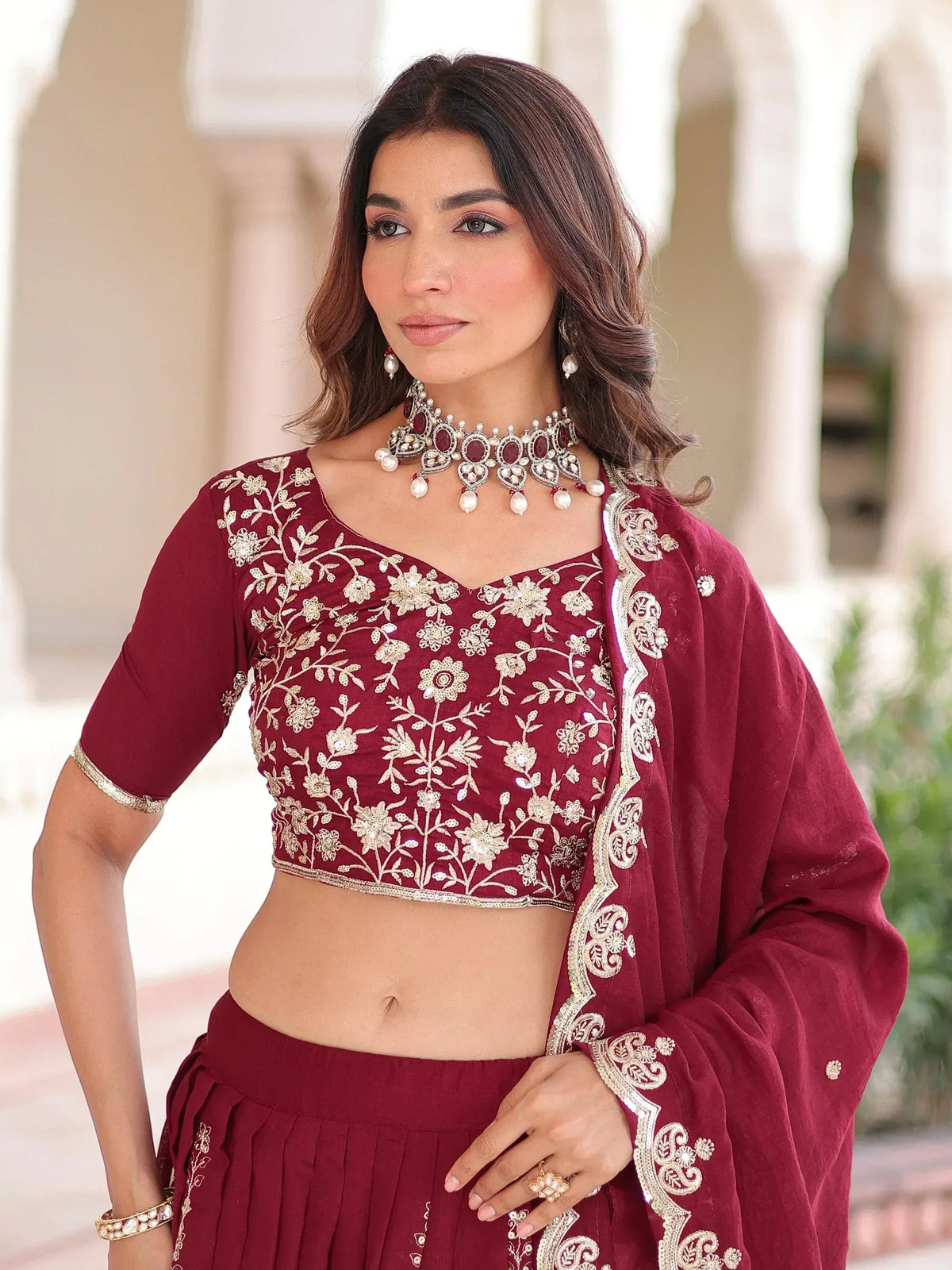 Maroon embroidered lehenga choli with gold floral designs and matching dupatta