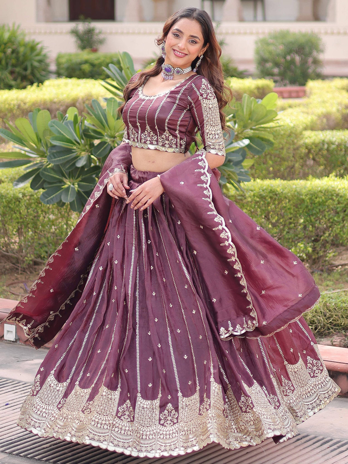 Burgundy designer lehenga choli with gold embroidery, perfect for Indian weddings and festive occasions.