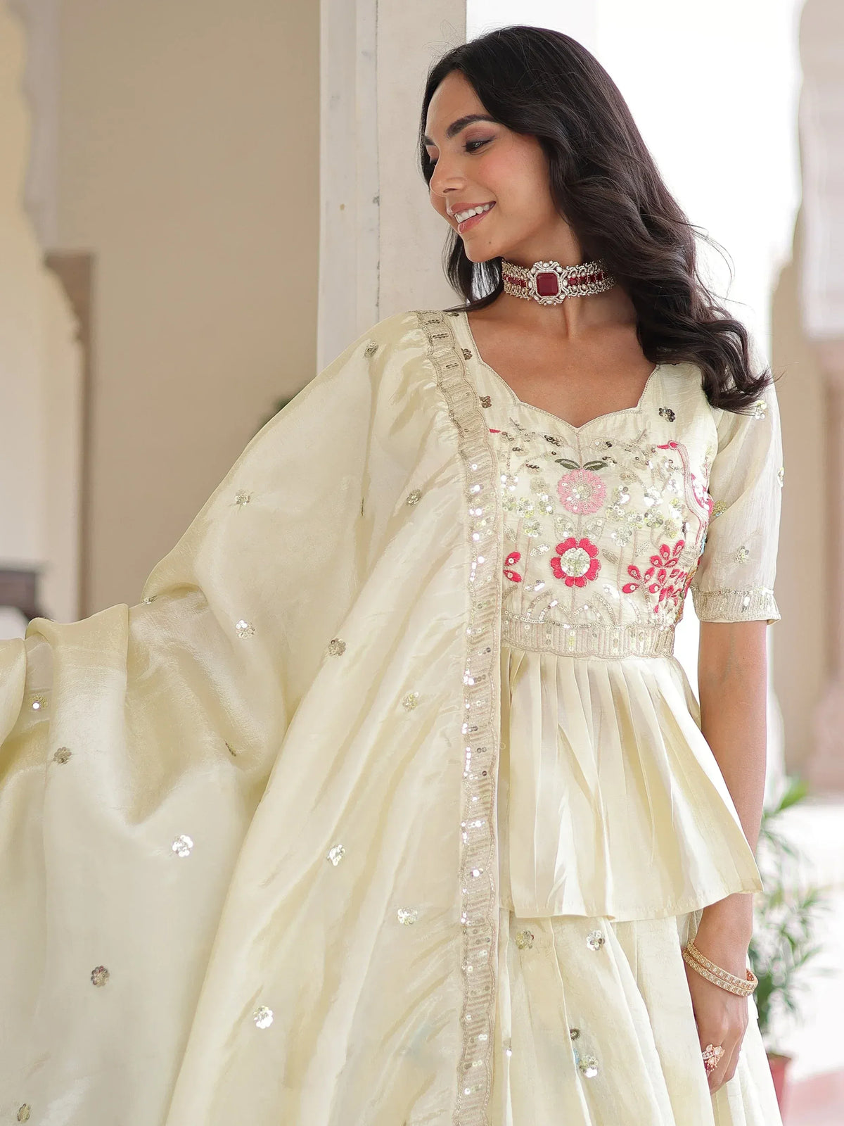 Elegant cream ethnic gown with floral embroidery and sequin detailing, perfect for Indian celebrations.