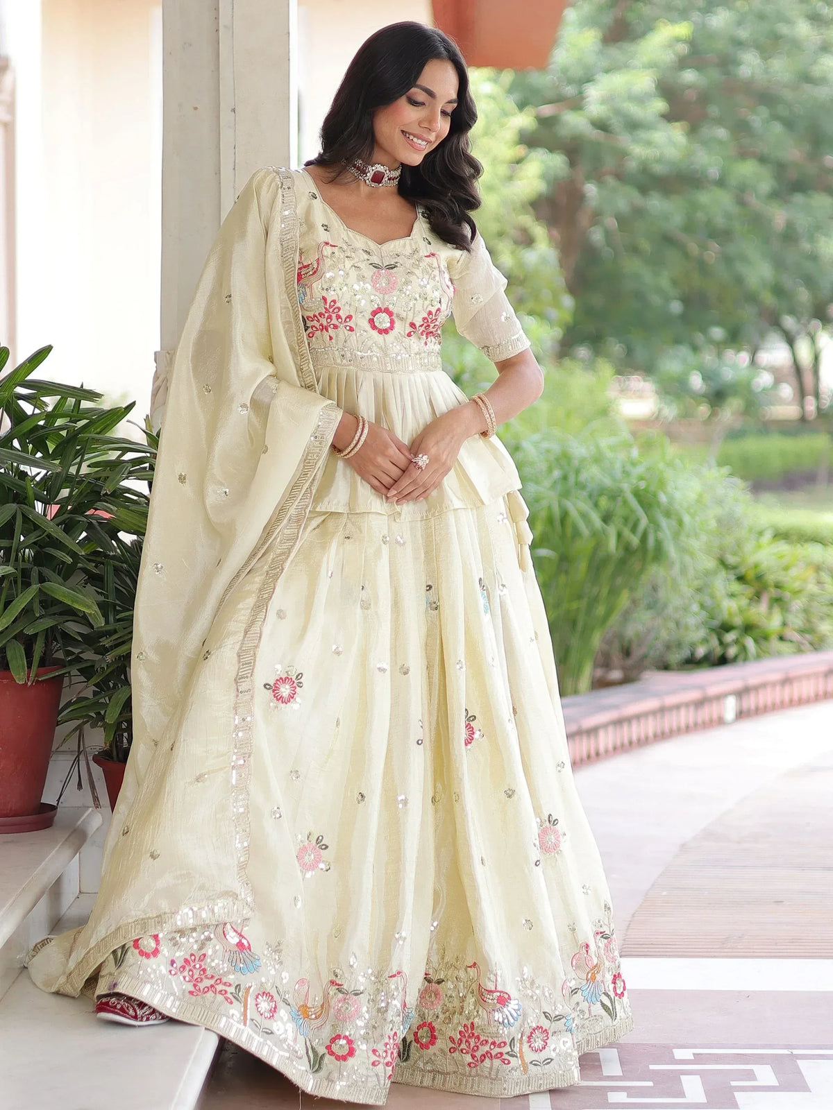Elegant cream lehenga choli with floral embroidery and mirror work, perfect for Indian ethnic wear occasions.