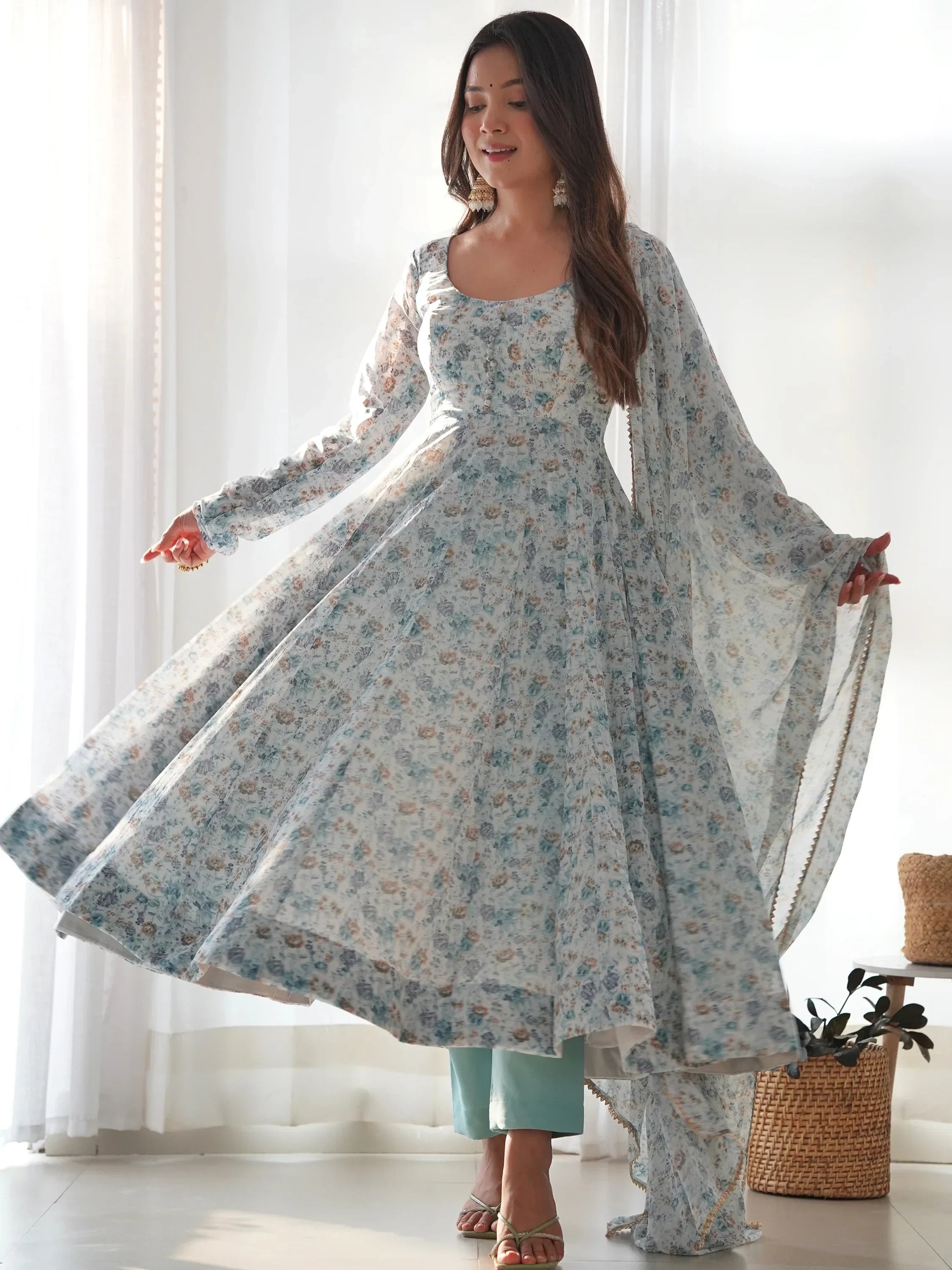 Woman in a pastel blue floral Anarkali suit with dupatta, Indian ethnic wear indoors