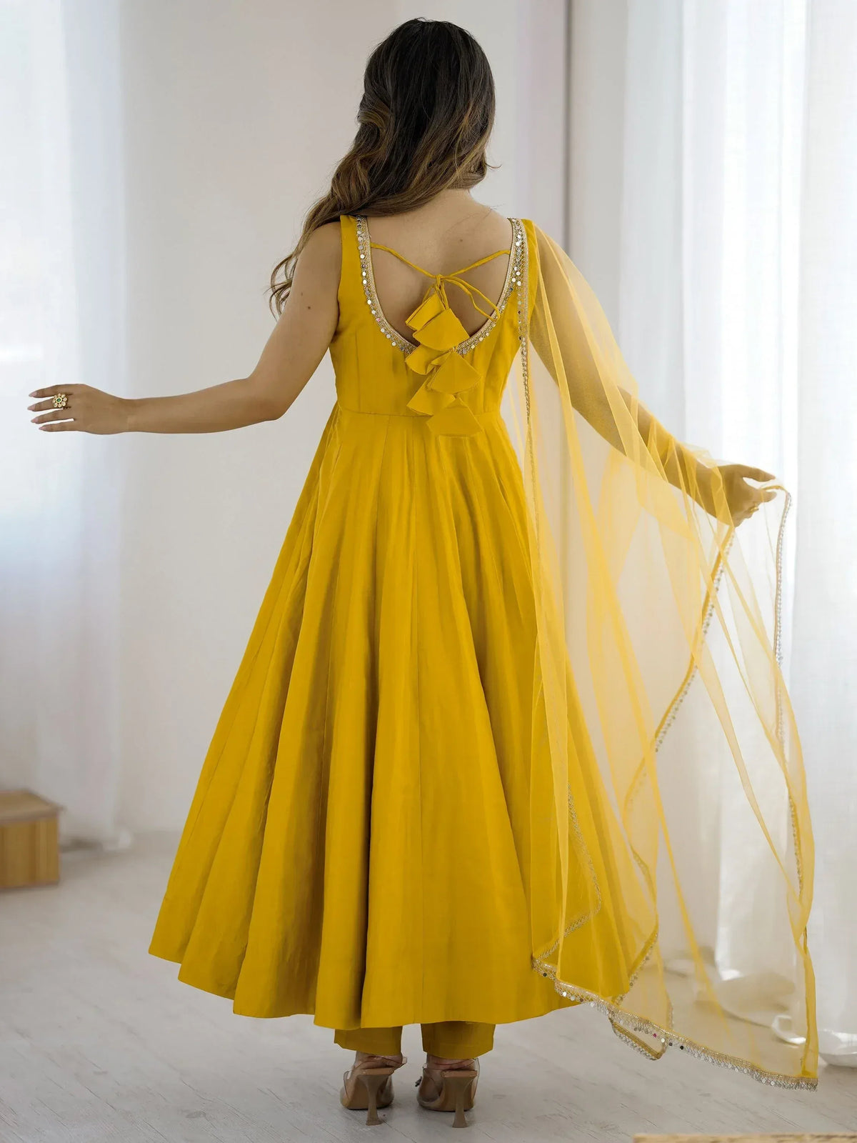 Yellow ethnic gown with ruffle back and sheer dupatta, perfect for Indian festive occasions
