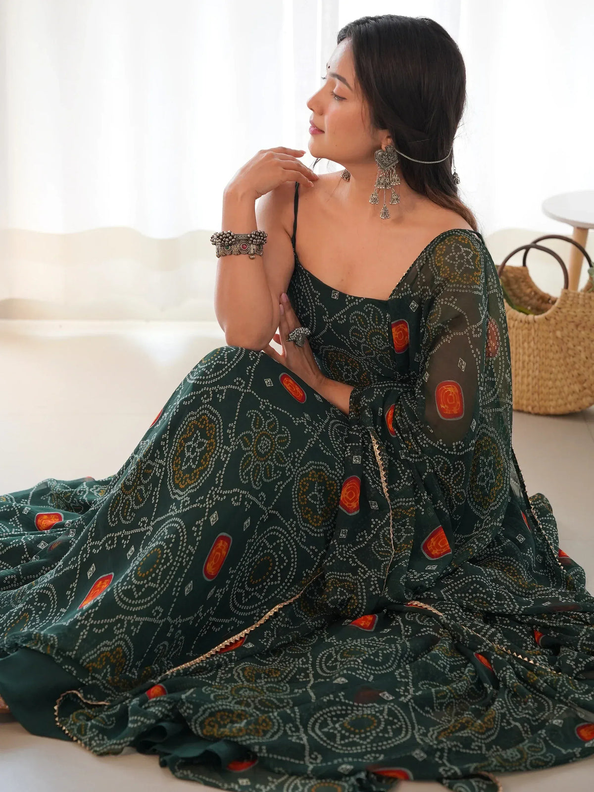 Elegant green ethnic gown with intricate patterns and traditional jewelry