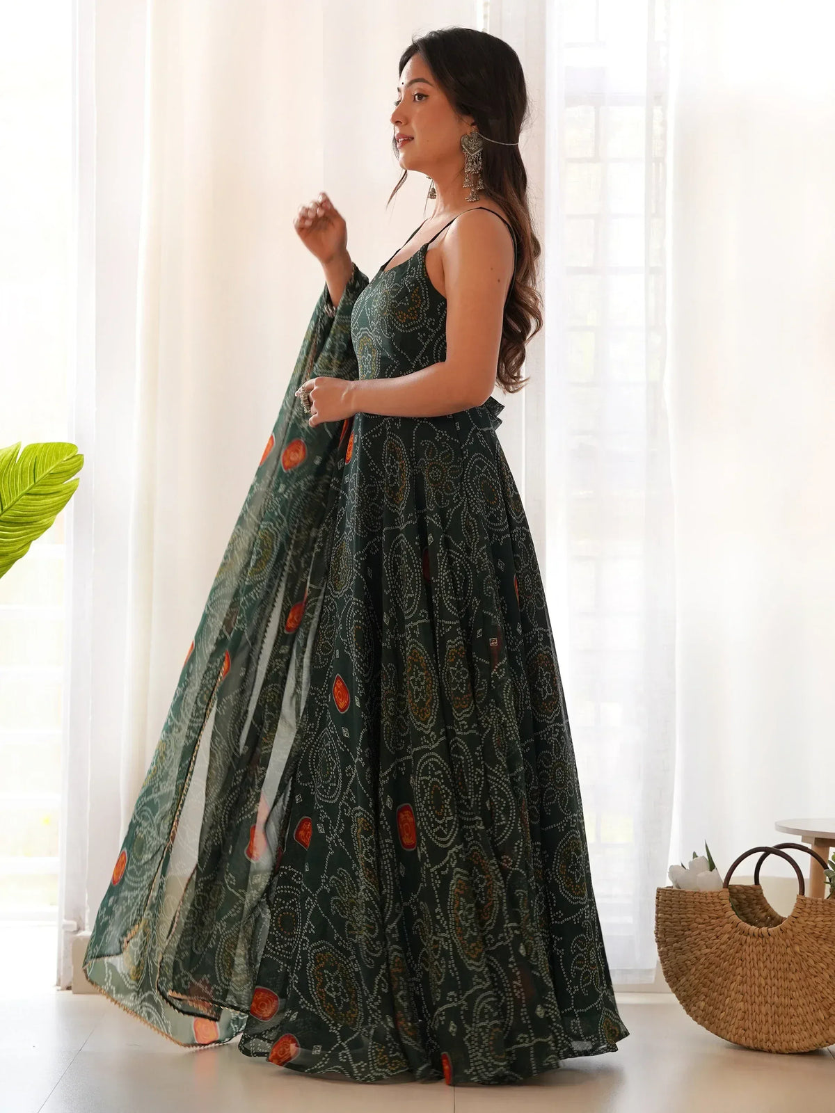 Woman in green printed ethnic gown with floral motifs, perfect for Indian occasions and festive wear.
