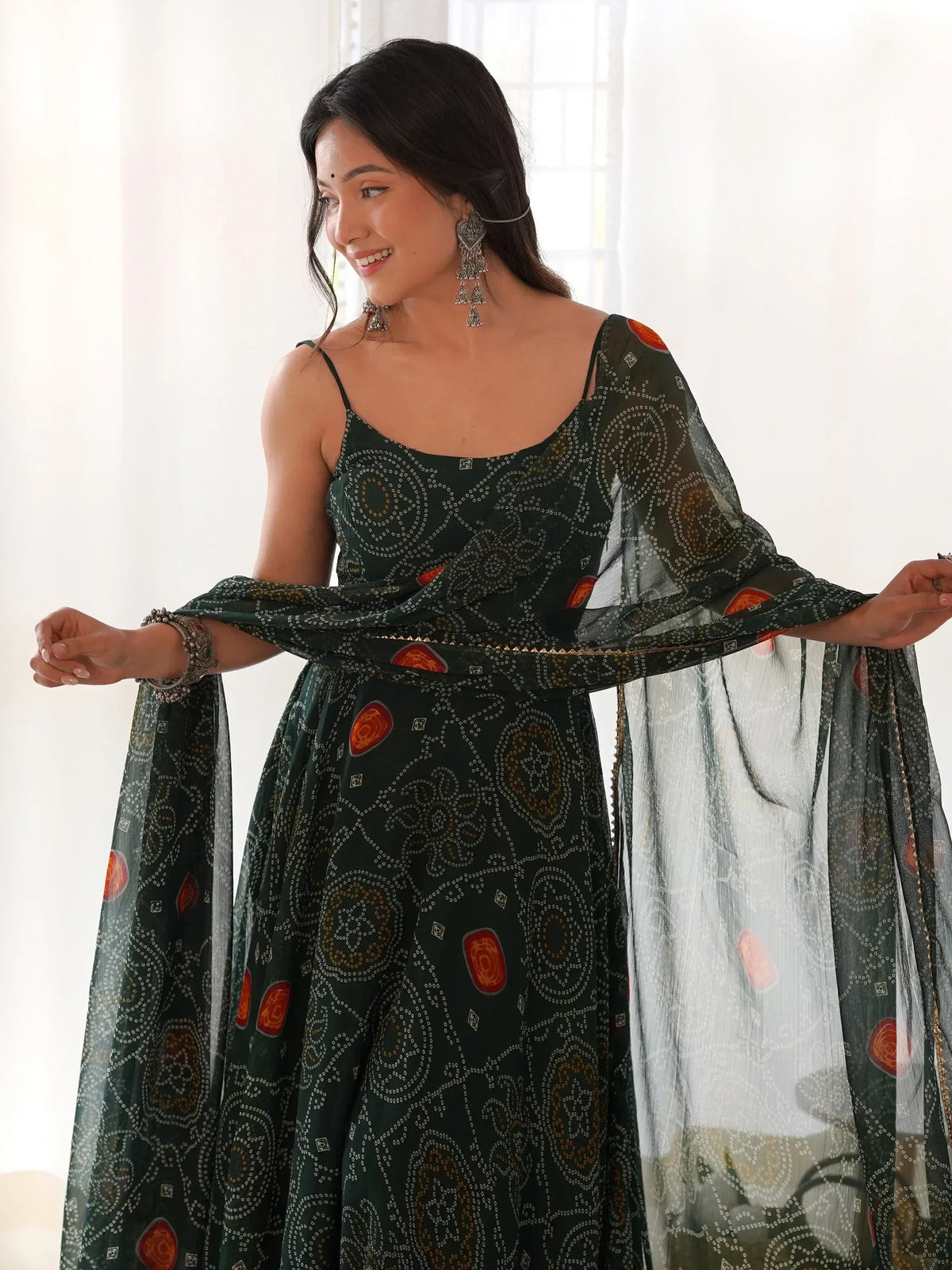 Woman in elegant green printed ethnic gown with sheer cape, perfect for festive occasions and Indian celebrations.