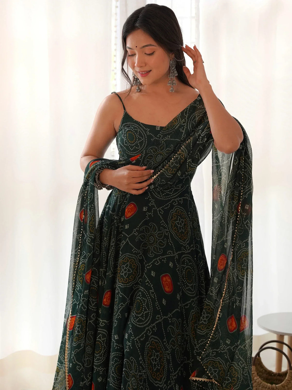 Elegant green printed ethnic gown with intricate patterns and gold detailing, perfect for festive occasions.
