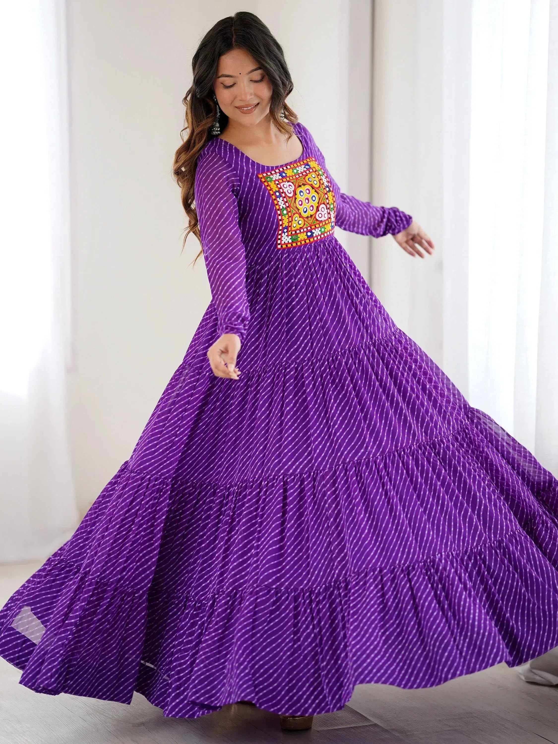Purple ethnic gown with embroidered panel, tiered skirt, and long sleeves for festive occasions