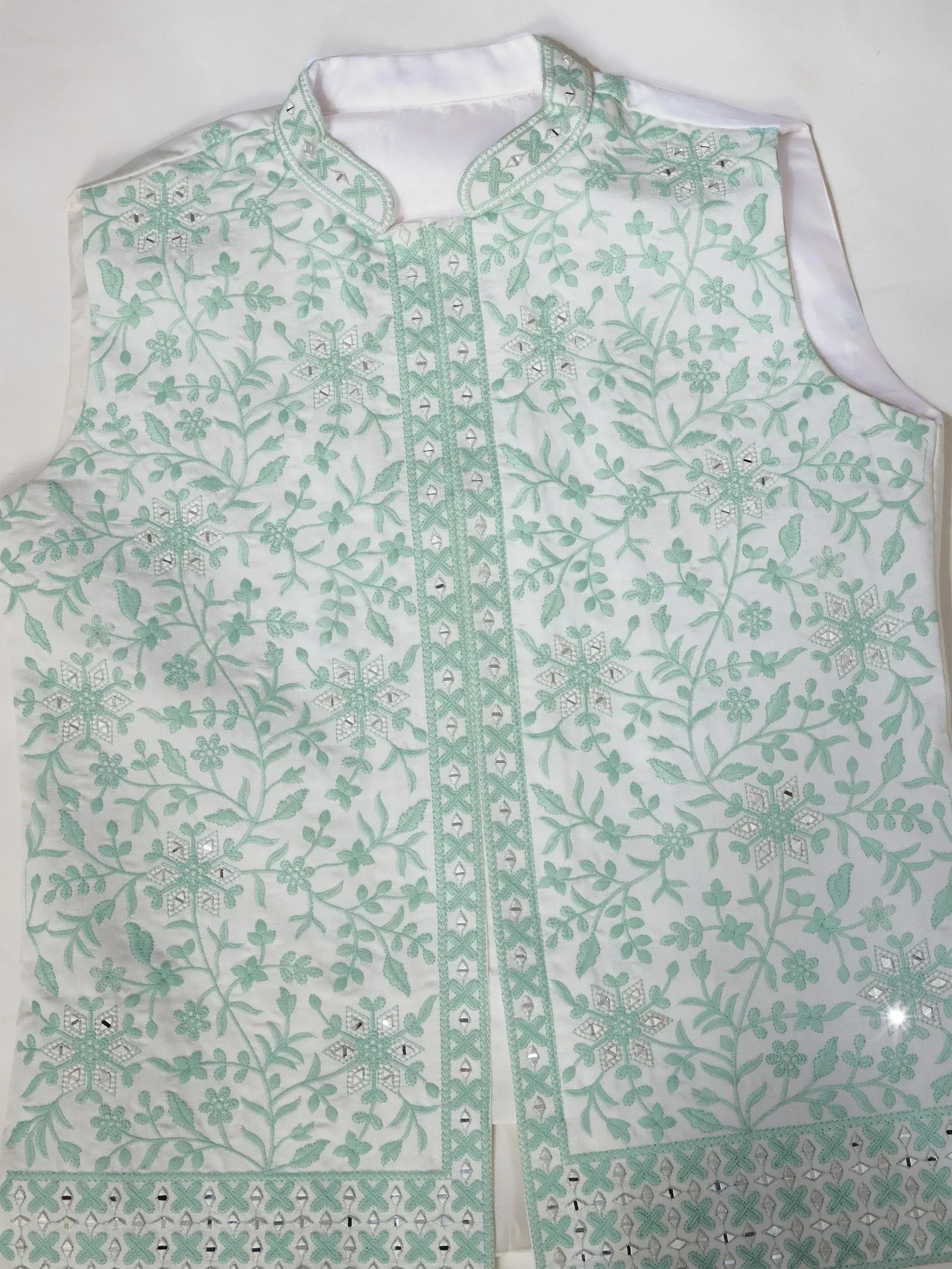 White sleeveless ethnic vest with mint green floral embroidery and mirror work, perfect for Indian wear.