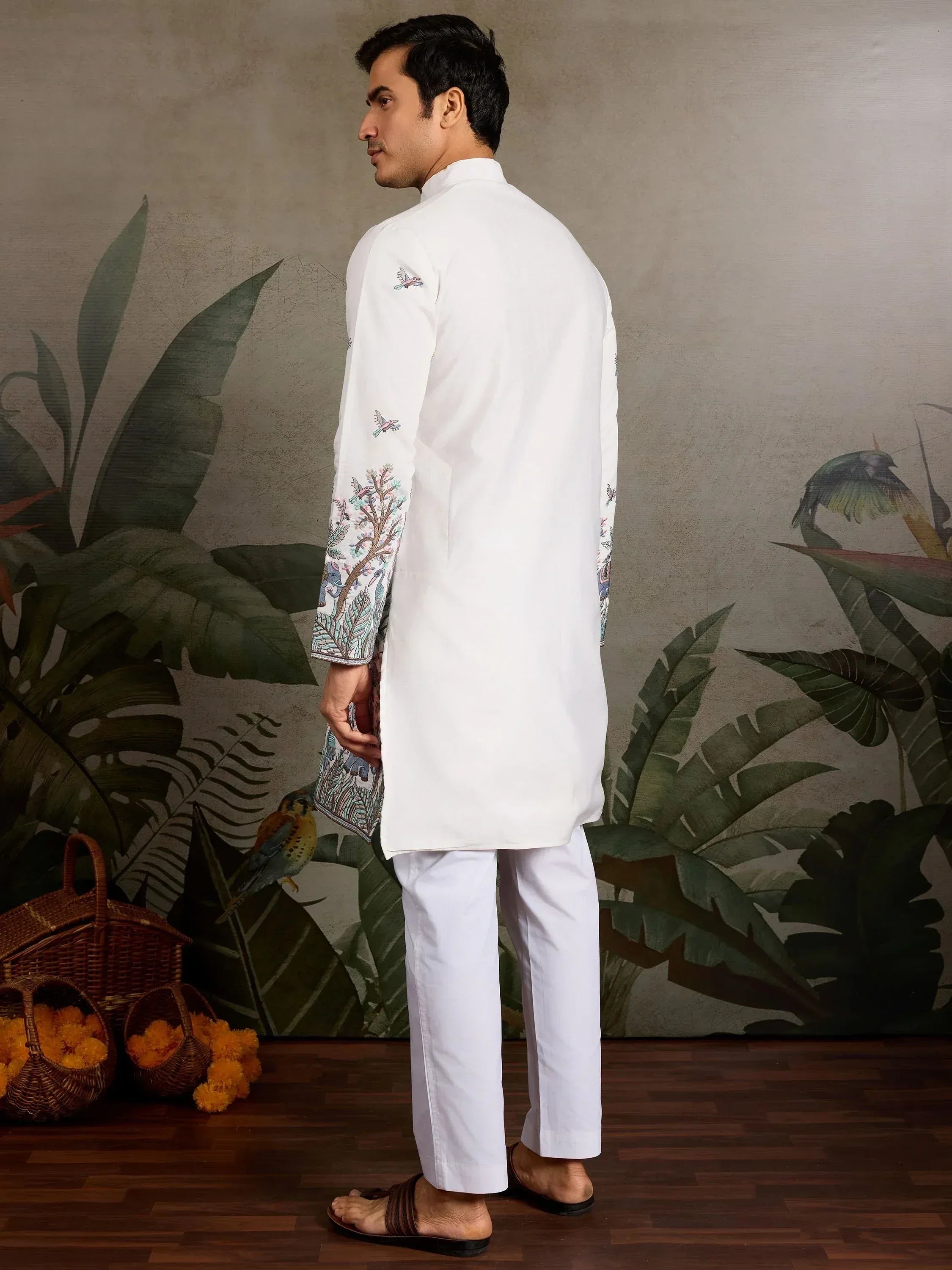 Man in white embroidered kurta with bird and tree motifs, paired with white pants, for ethnic wear