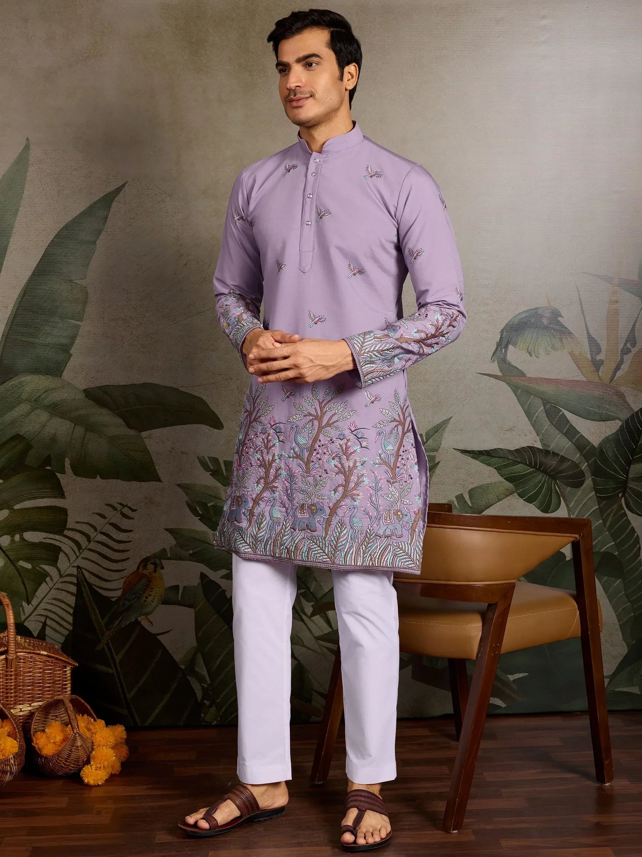 Man wearing lavender embroidered kurta with bird and tree motifs, paired with white pants for ethnic wear