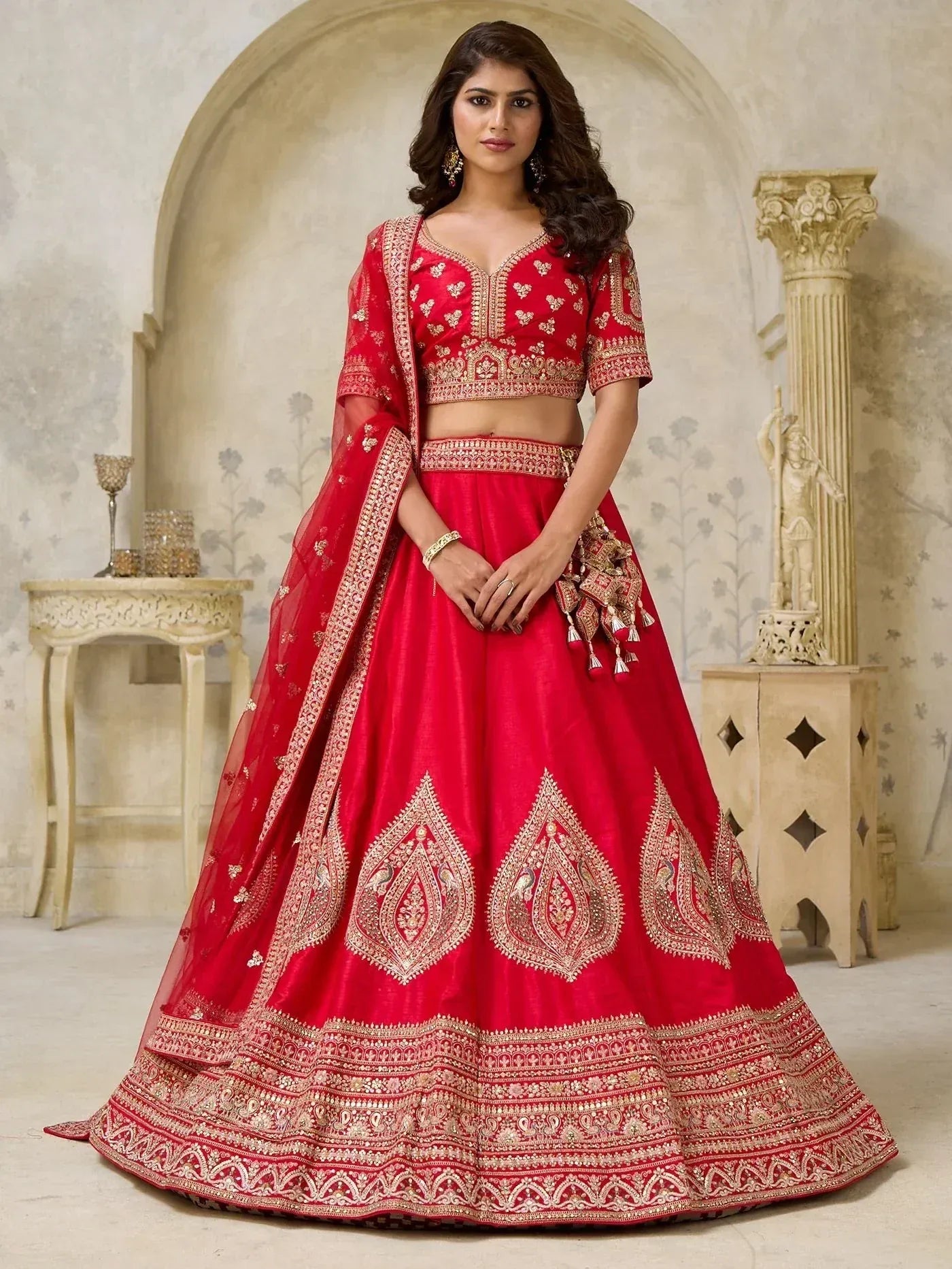 Red embroidered lehenga choli with gold detailing, perfect for Indian weddings and festive occasions.