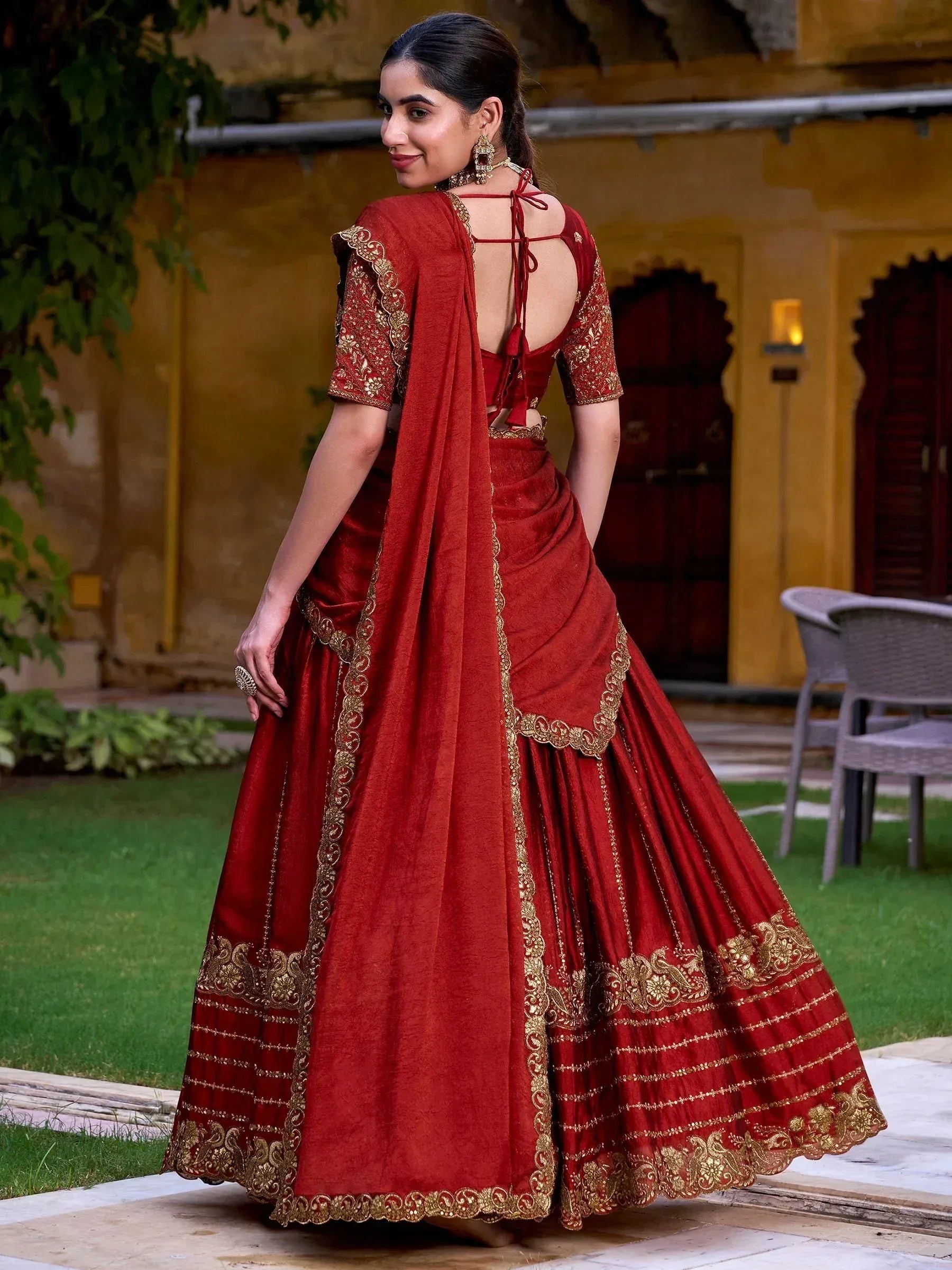 Red designer lehenga choli with gold embroidery, back view, ethnic wear for weddings