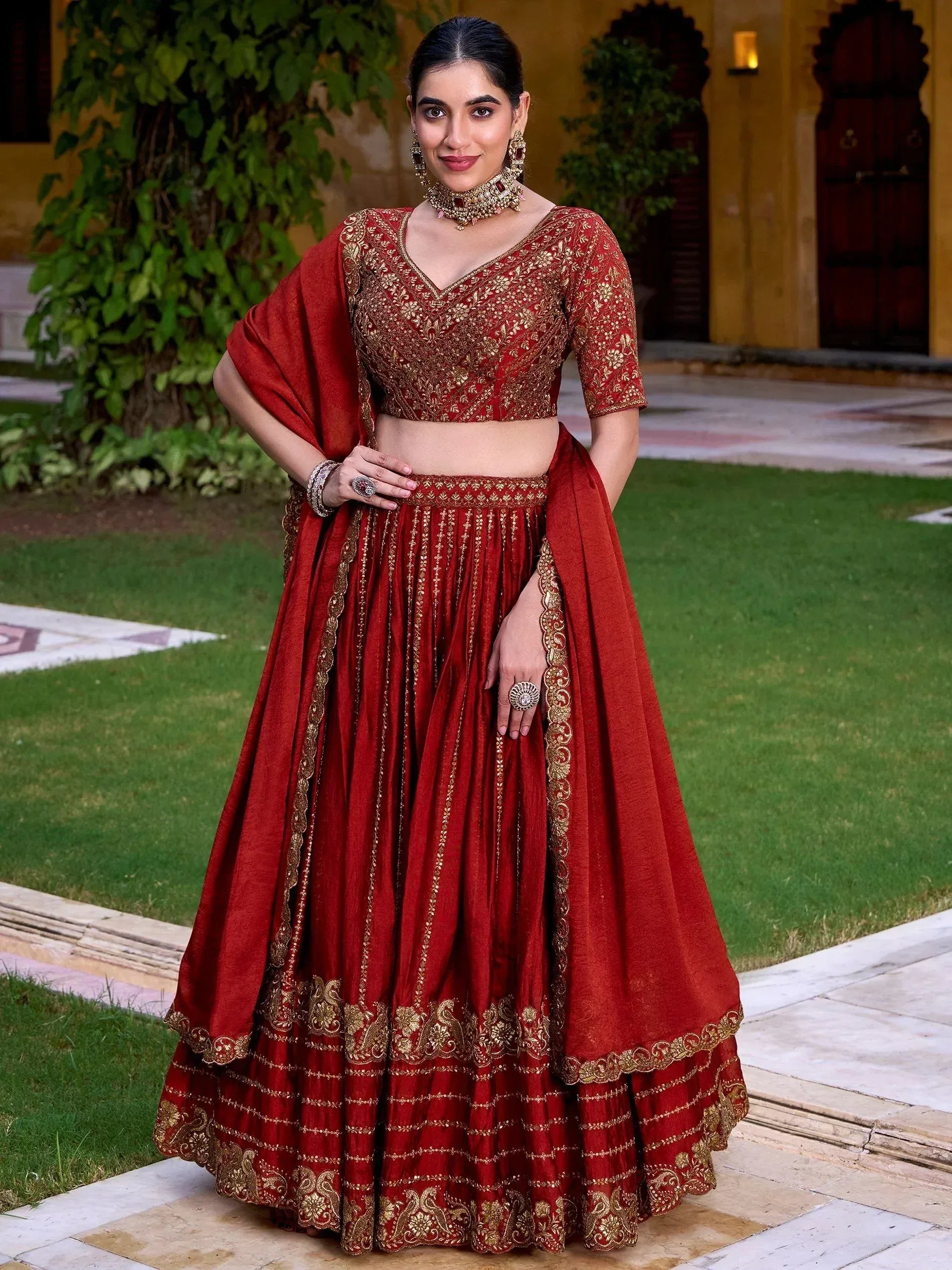 Red and gold embroidered lehenga choli with dupatta, perfect for Indian weddings and festive occasions.