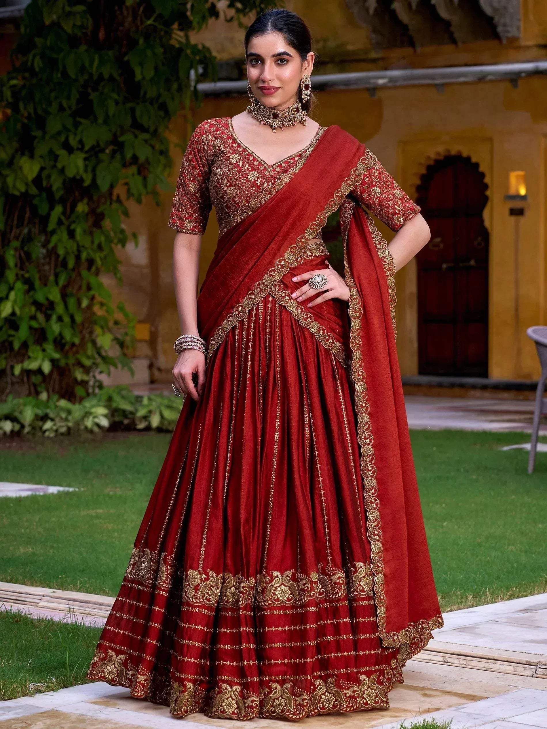 Red velvet lehenga choli with gold embroidery, perfect for Indian weddings and festive occasions.