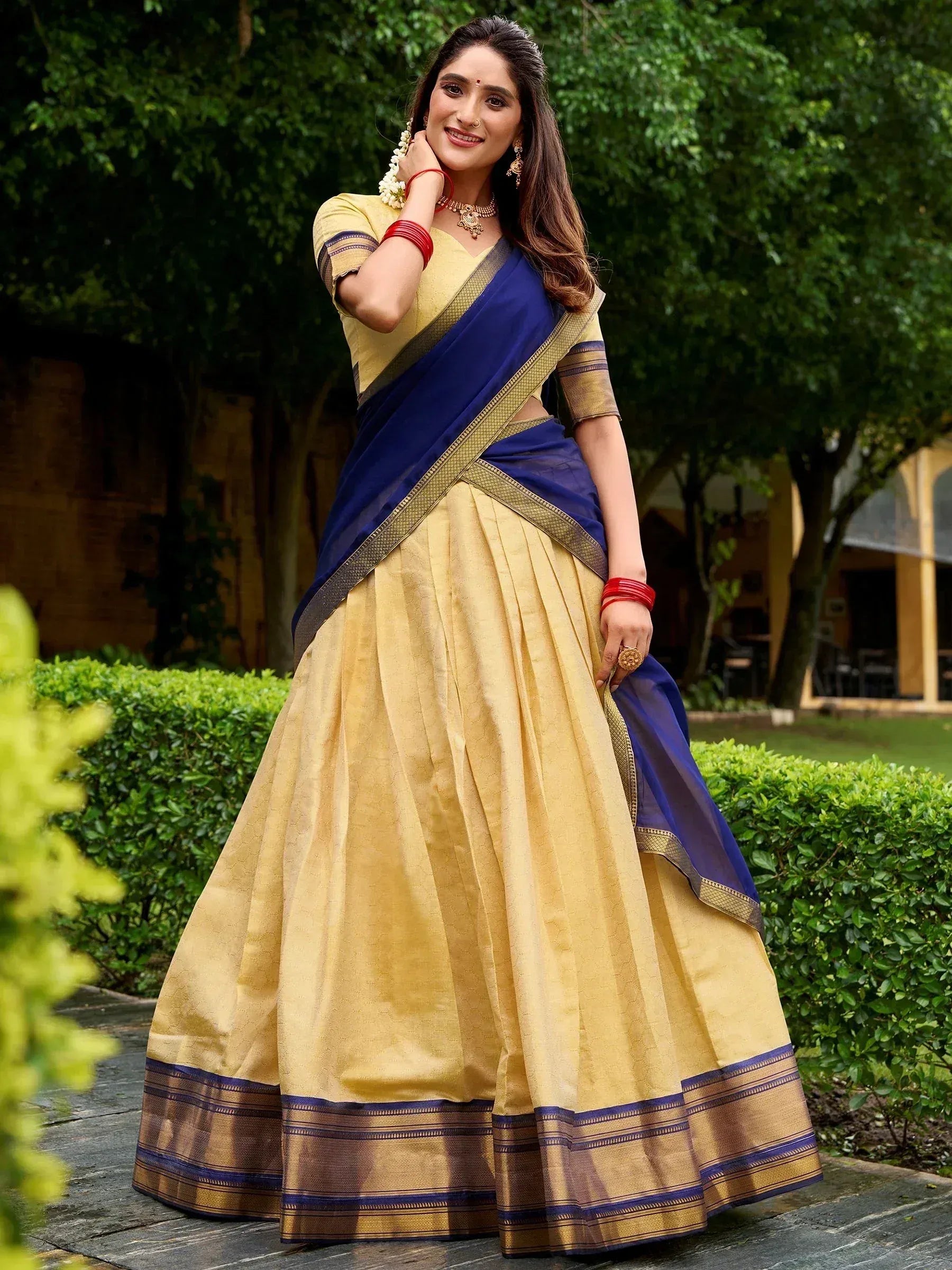 Woman in elegant yellow and navy blue saree with gold border, perfect for Indian ethnic occasions
