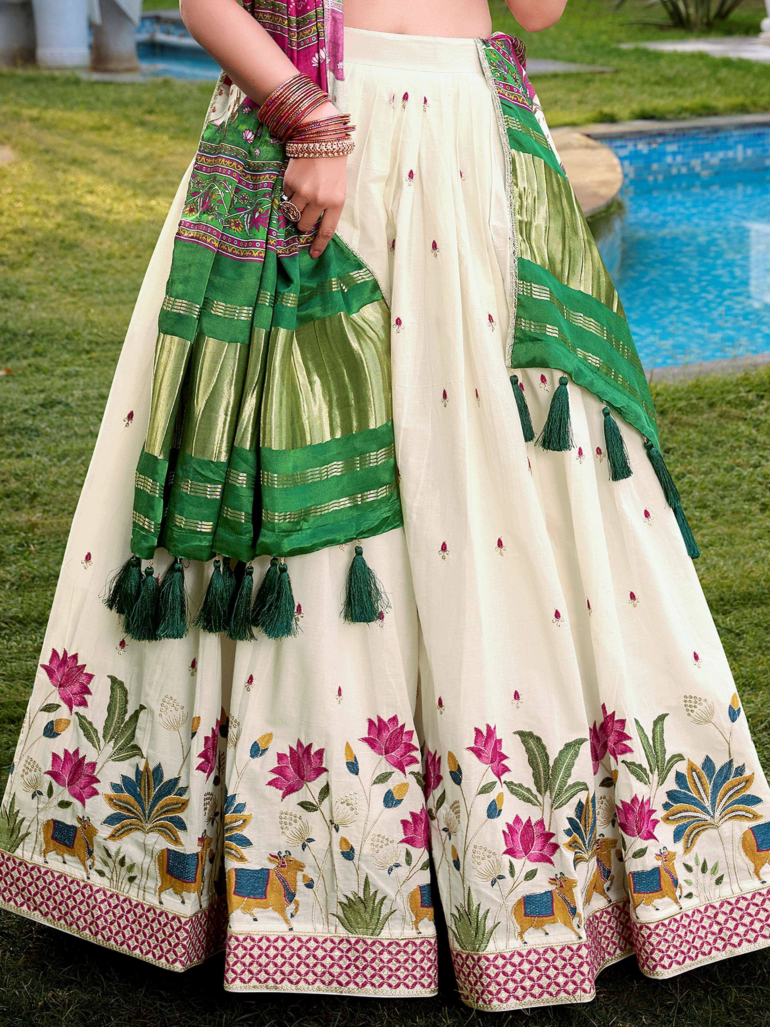 Cream floral embroidered lehenga with green dupatta, tassels, and traditional Indian motifs for ethnic wear