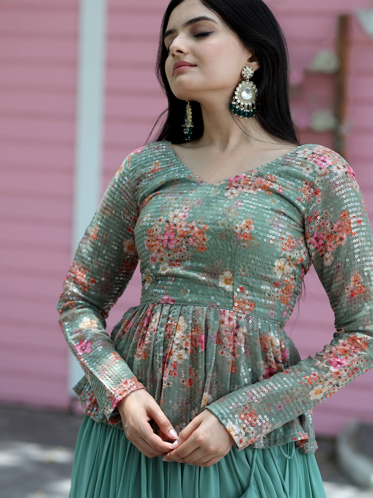 Green floral sequin ethnic gown with long sleeves and pleated skirt, paired with statement earrings