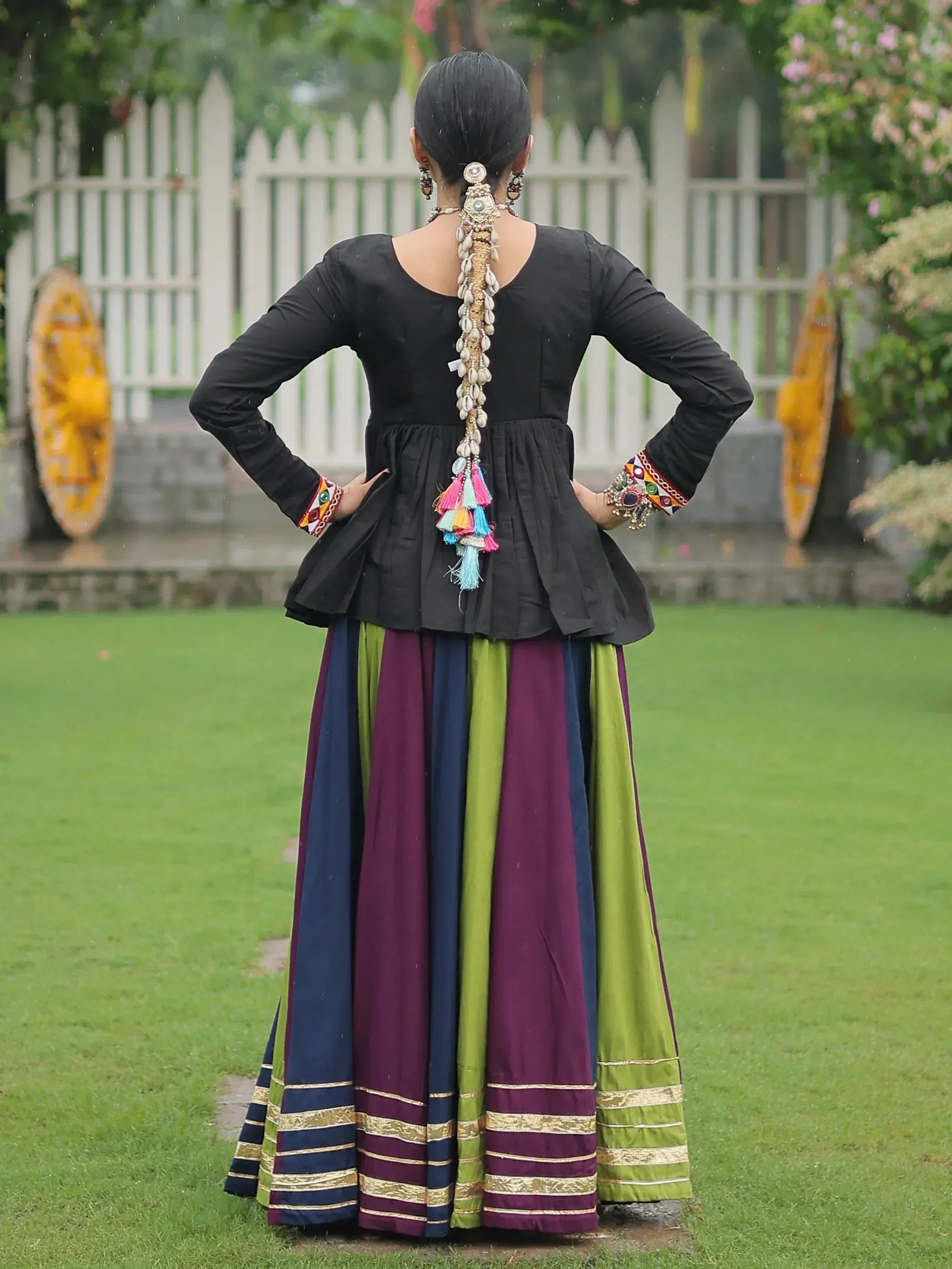 Black peplum top with colorful striped skirt, ethnic Indian wear, shell hair accessory, garden setting