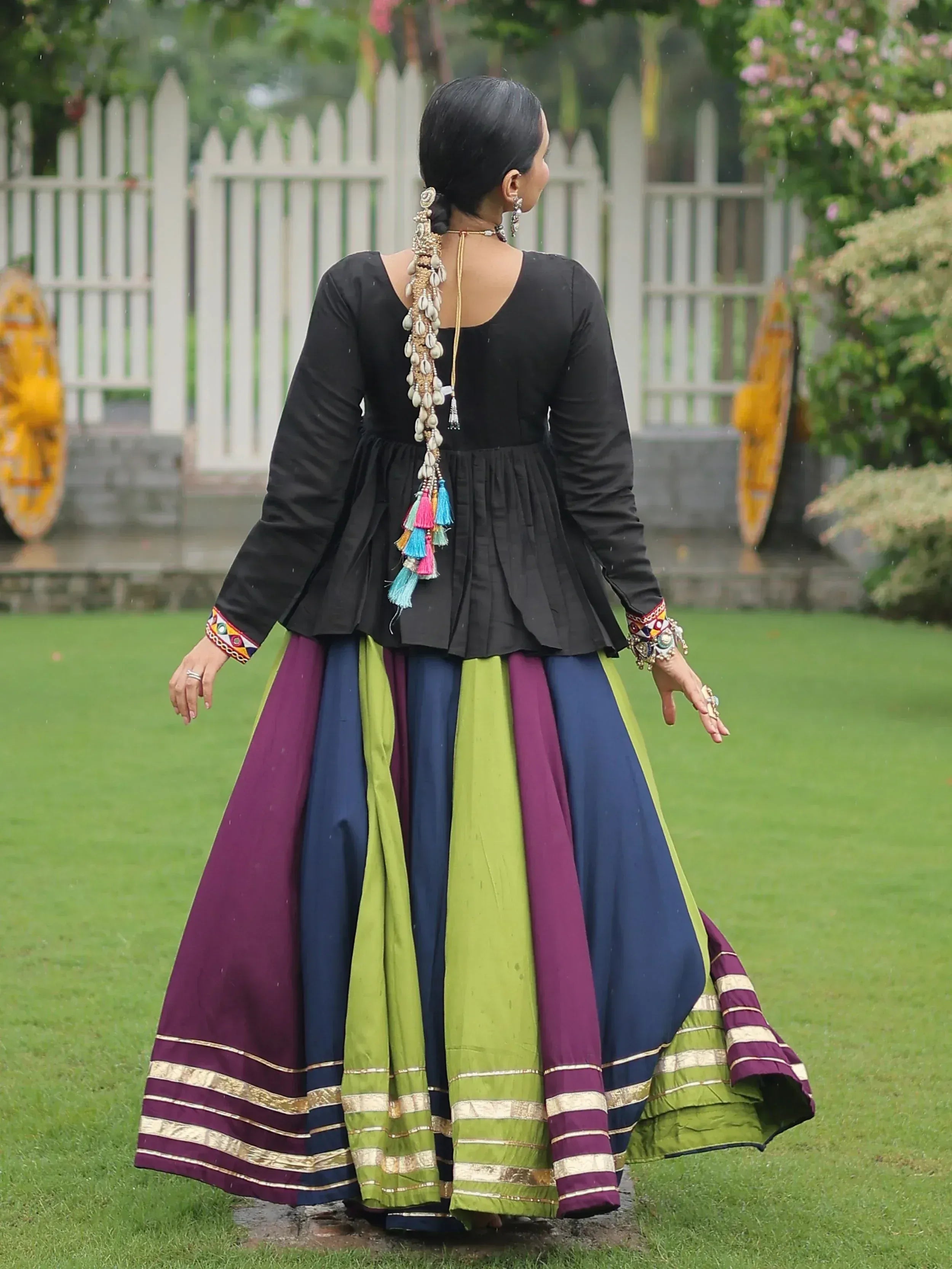 Black peplum top with colorful striped lehenga, shell hair accessory, ethnic Indian wear